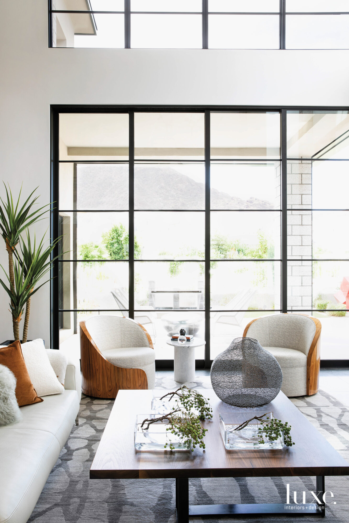 A grouping of white and wood swivel chairs in the corner of a modern organic living room.