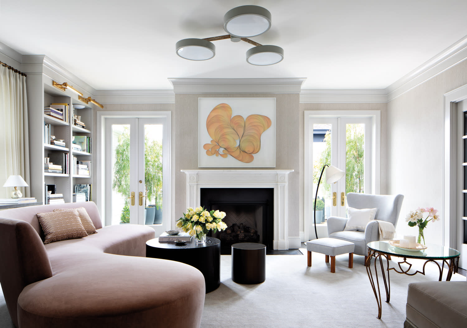 A curved sofa in a living room with neutral and blush tones