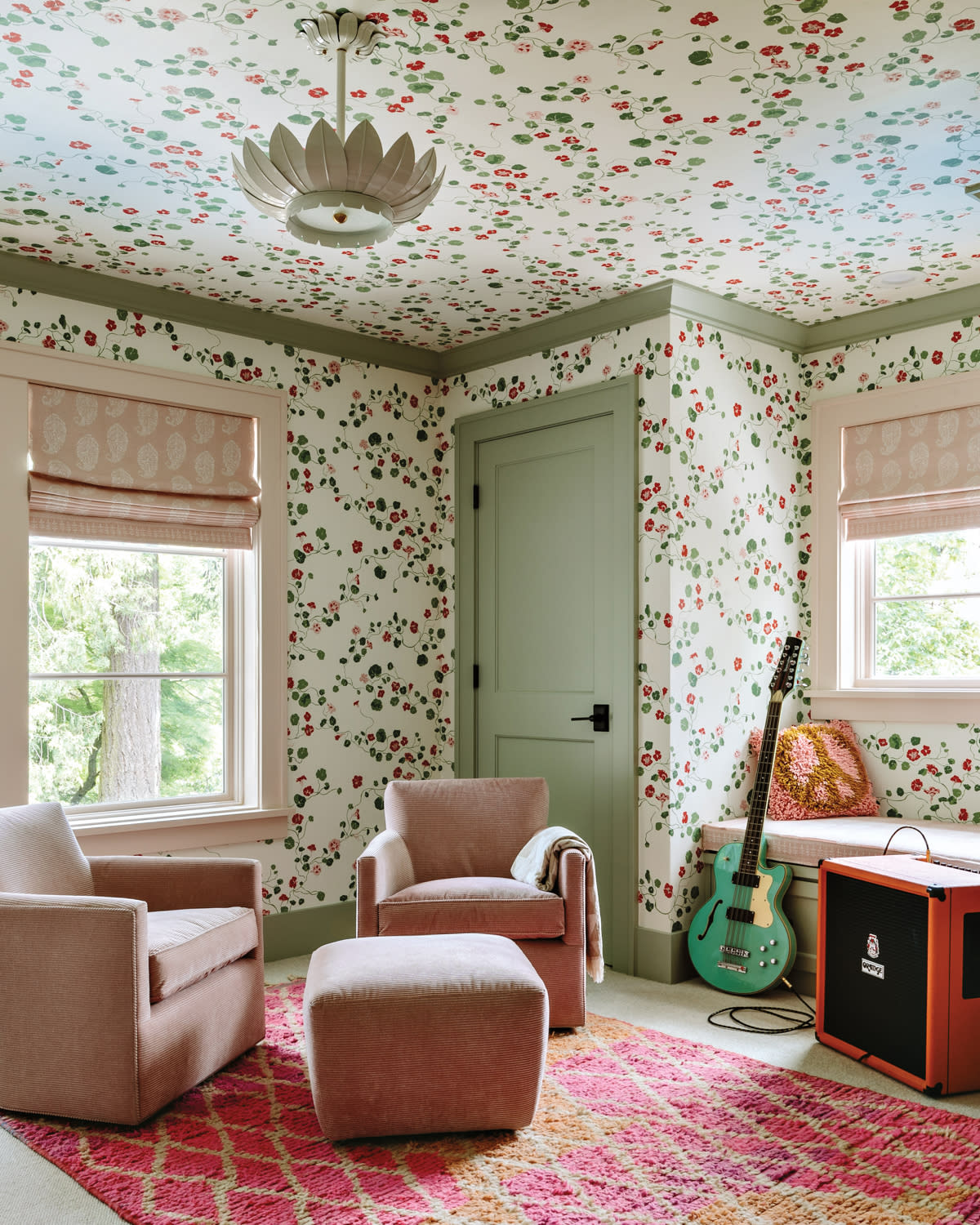 kids room with a floral wallcovering around the walls and ceiling and pink armchairs