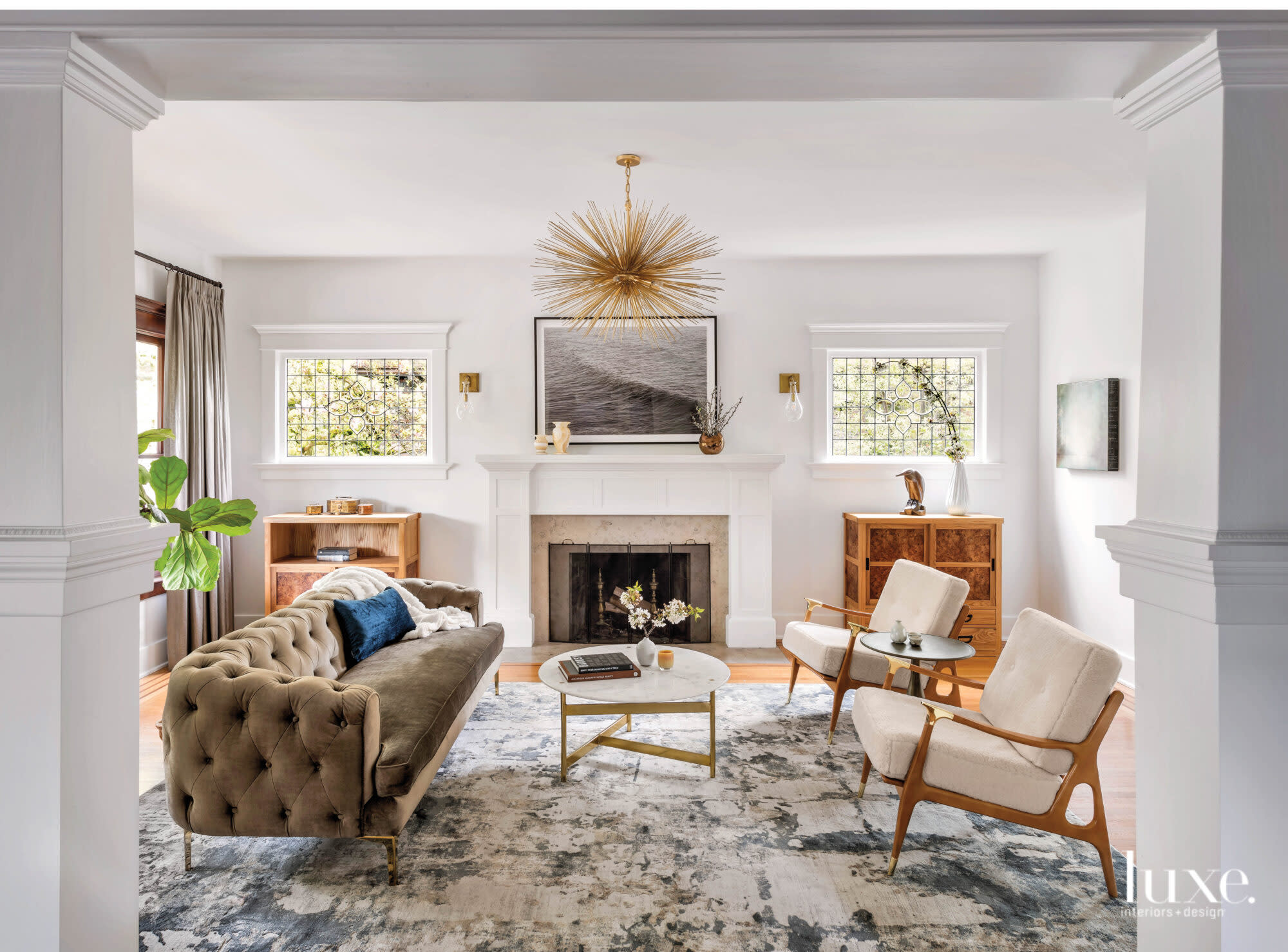 Living room with a tufted sofa facing a pair of midcentury modern wood frame lounge chairs