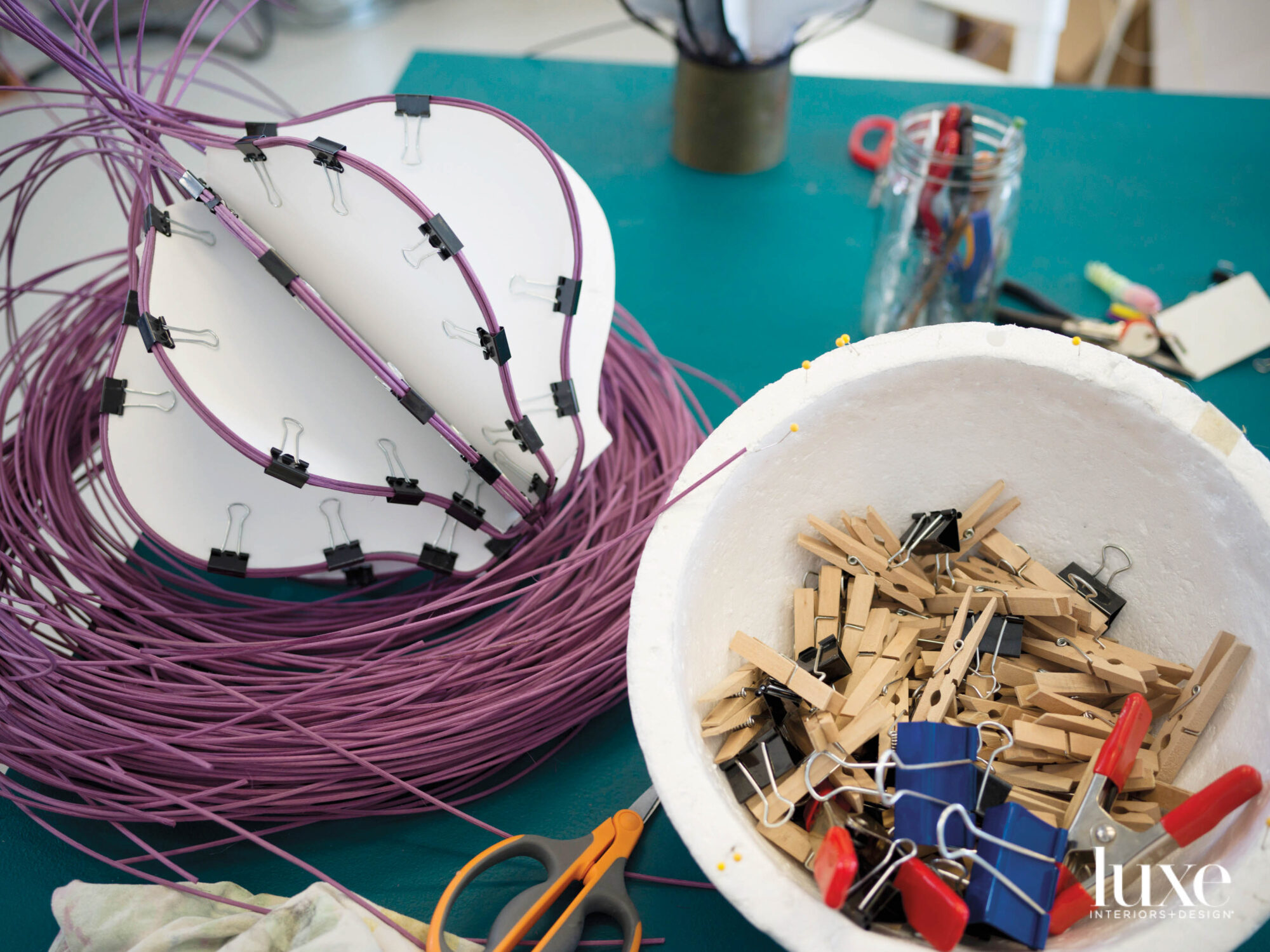 Purple fiber to be woven into a basket, clothespins and binder clips.