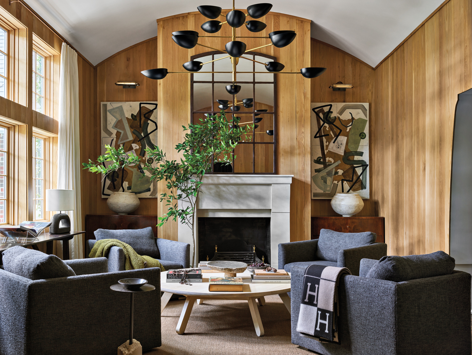 Living room with barrel vaulted ceiling, large-chandelier and symmetrical twin chests flanking the fireplace