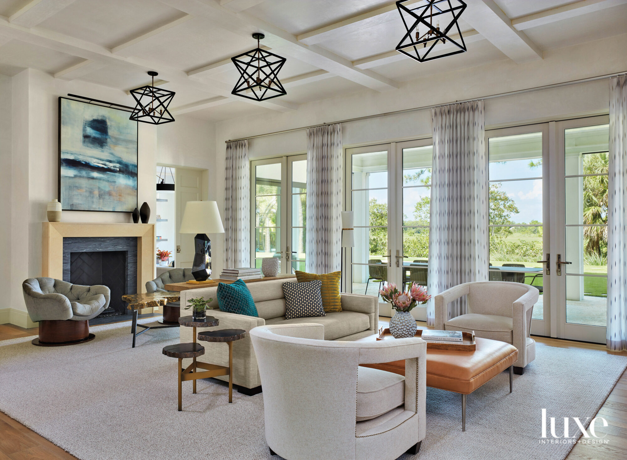 living area with three iron chandeliers, fireplace and two seating areas