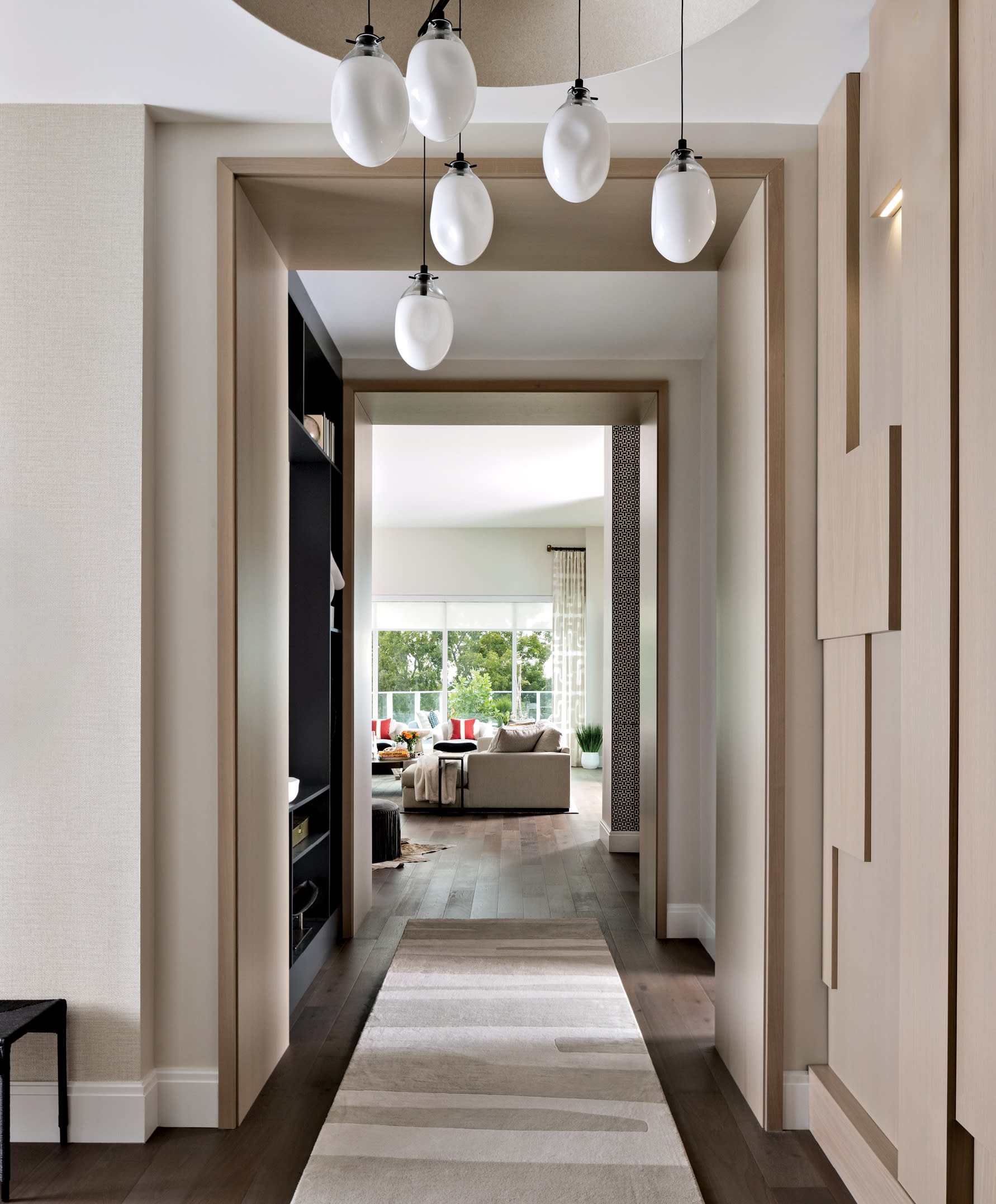 entry hall with Sonneman’s Liquid chandelier hanging above a gray rug