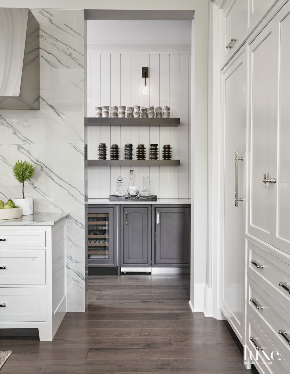 traditional white kitchen with dark gray cabinetry in pantry