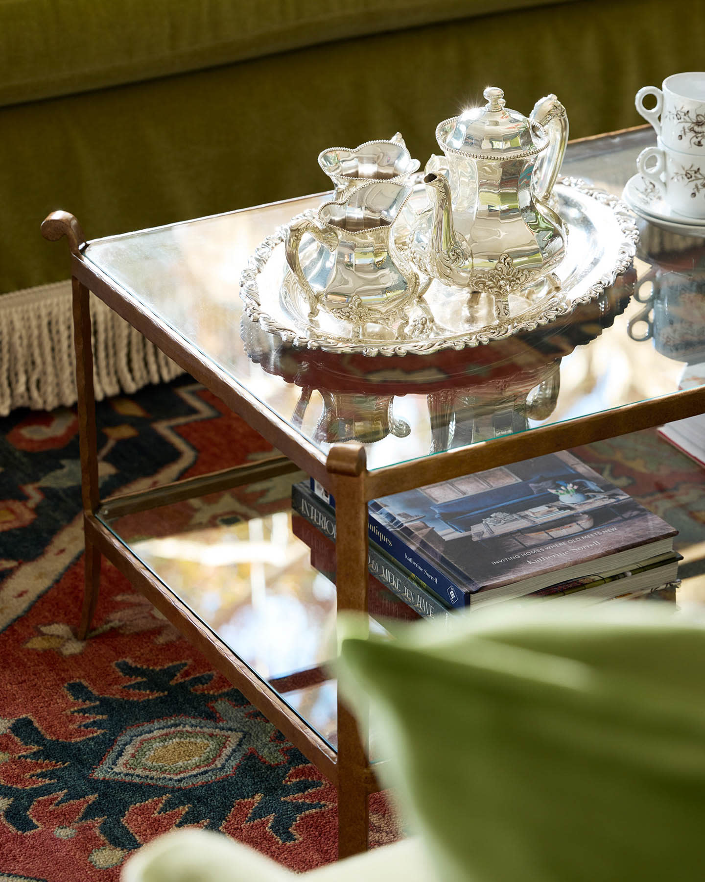 double shelf glass coffee table with a glass tea set atop it