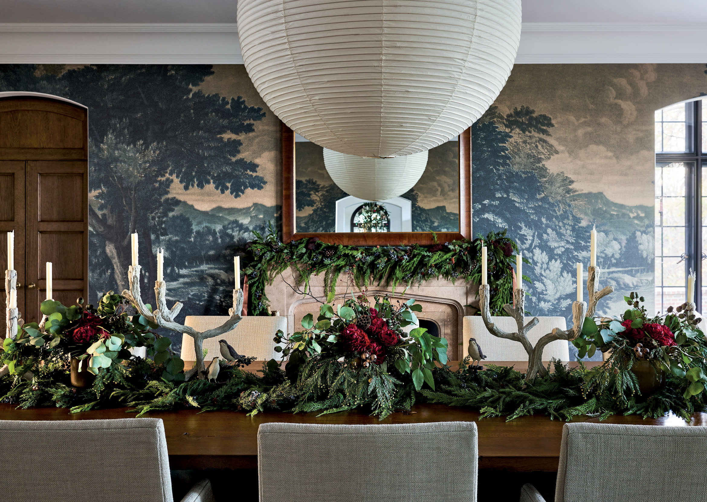 evergreens draping over dining table in traditional dining room with round lighting fixture