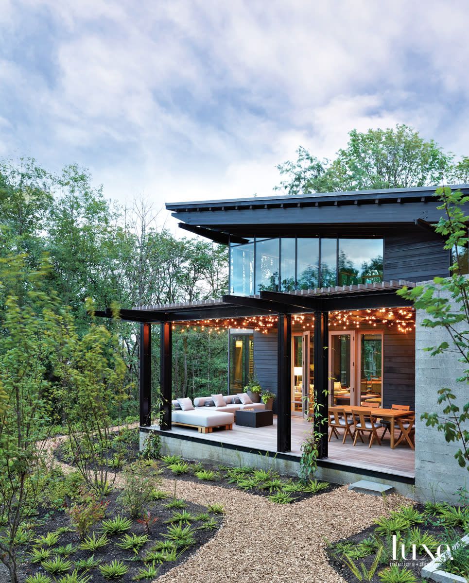 exterior of the backyard with patio, two sitting areas and lights