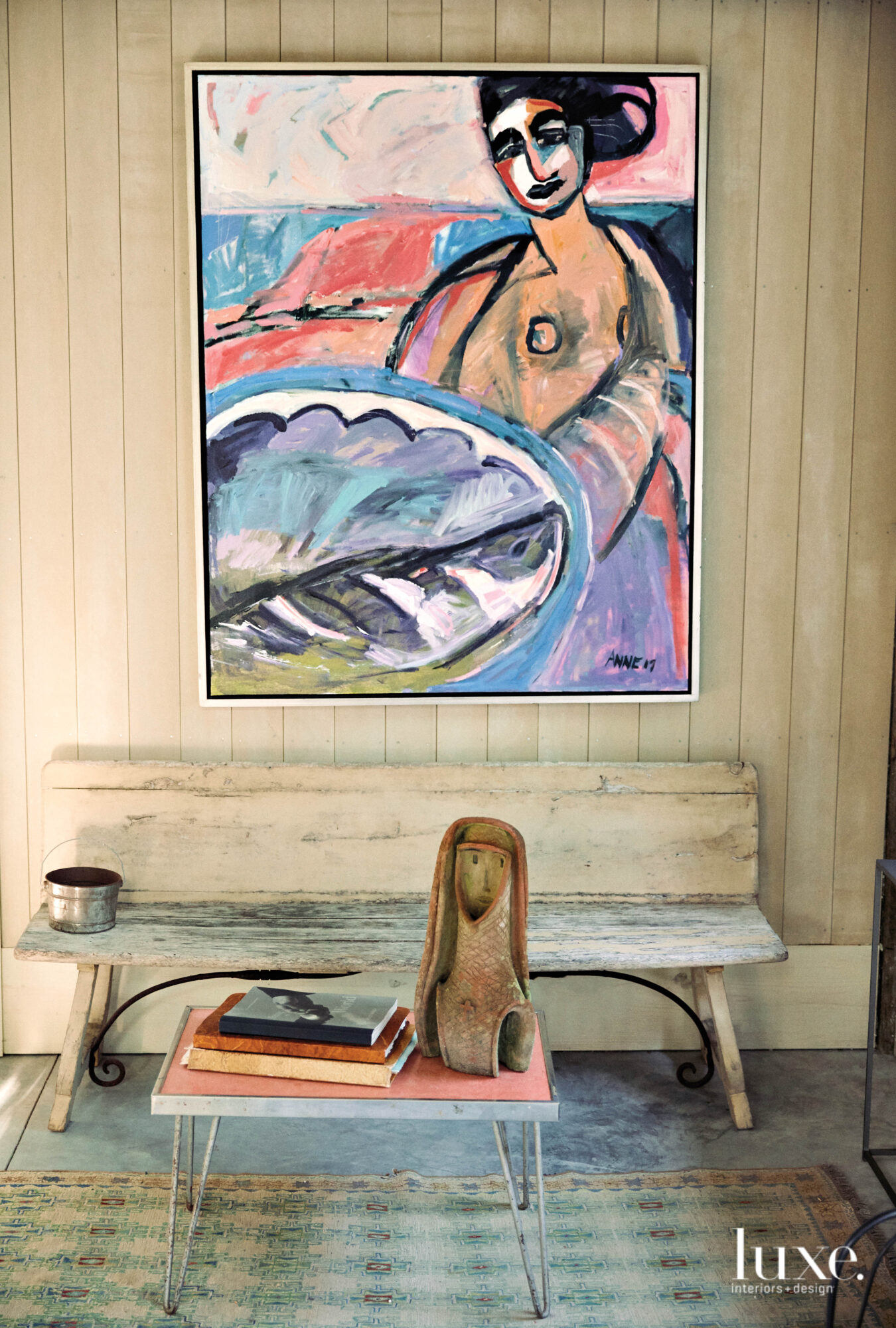 Bench with figurative painting on the paneled wall above it