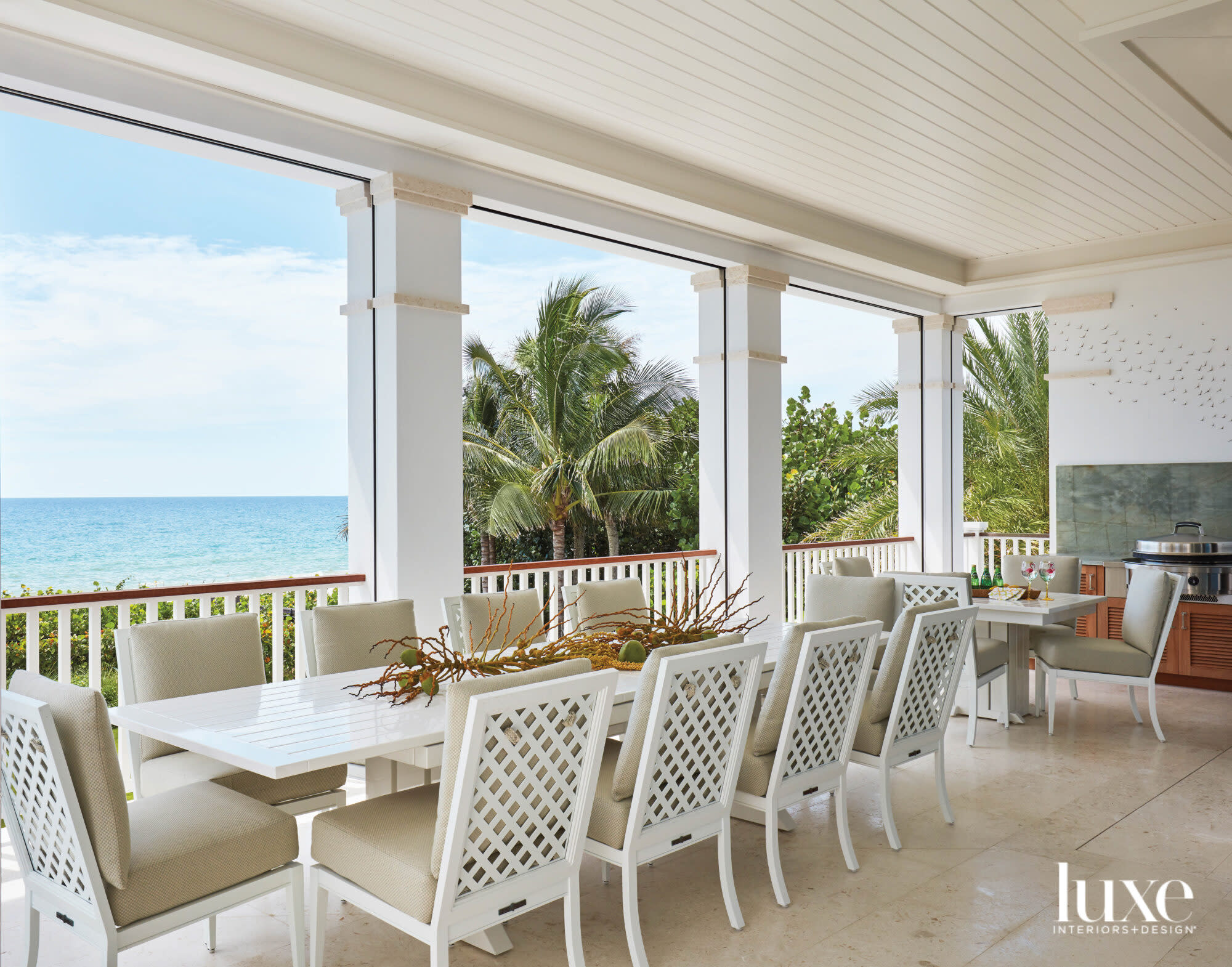 Lanai with dining table and chairs overlooking ocean.