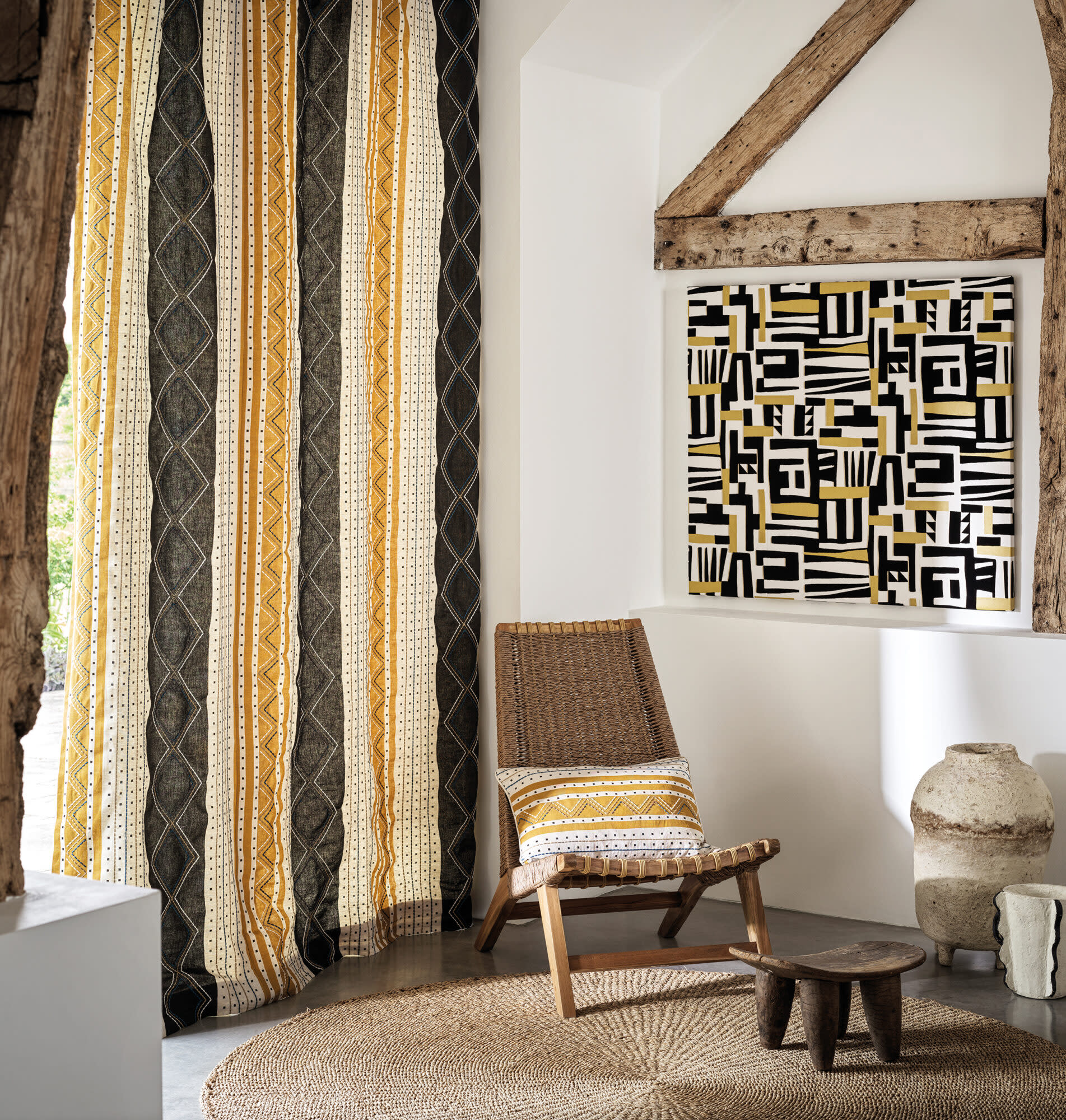 room with yellow and brown striped drapes, patterned artwork and chair