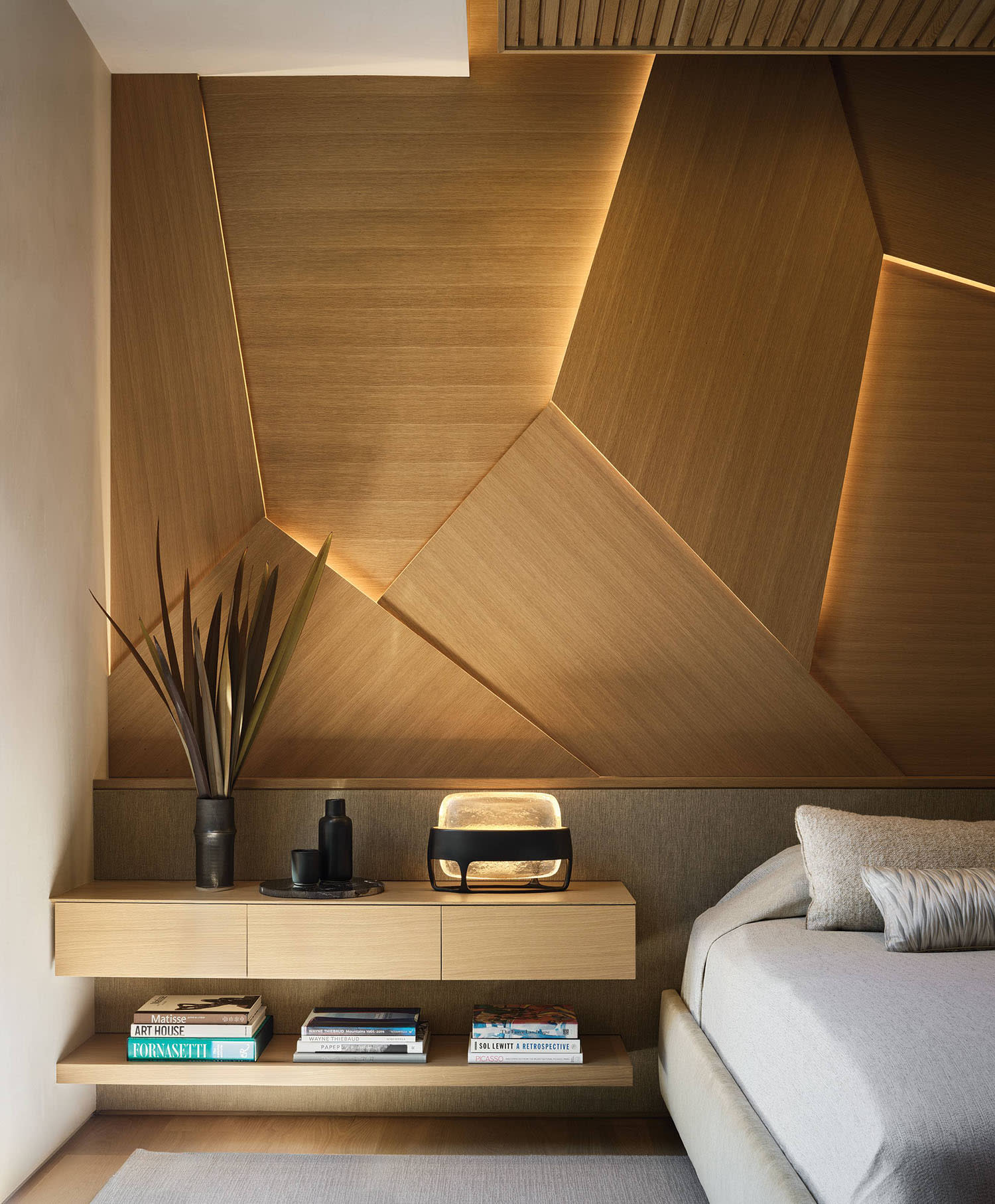 bedroom with backlit wall panels and nightstand