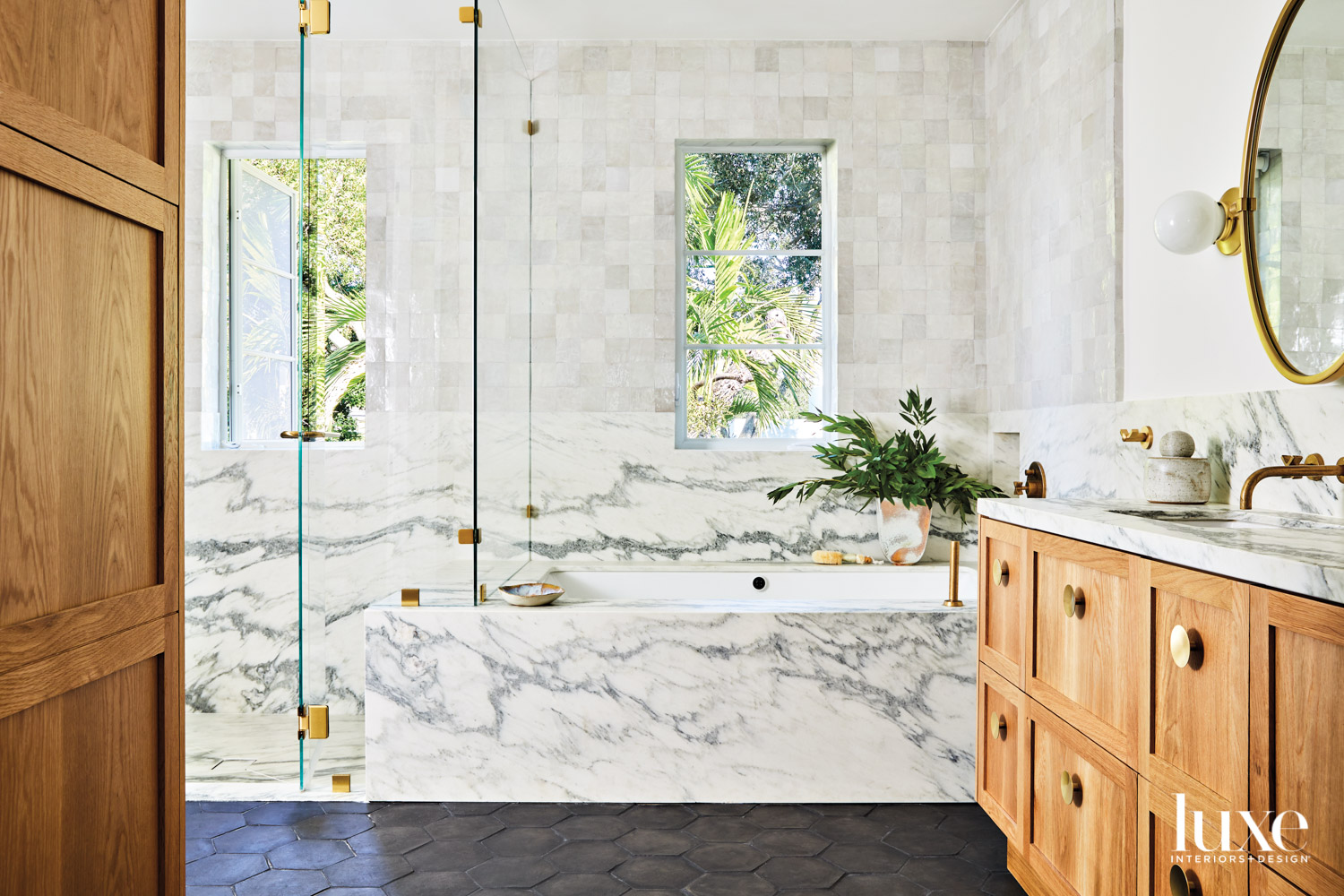 bathroom with marble tub and black tile flooring