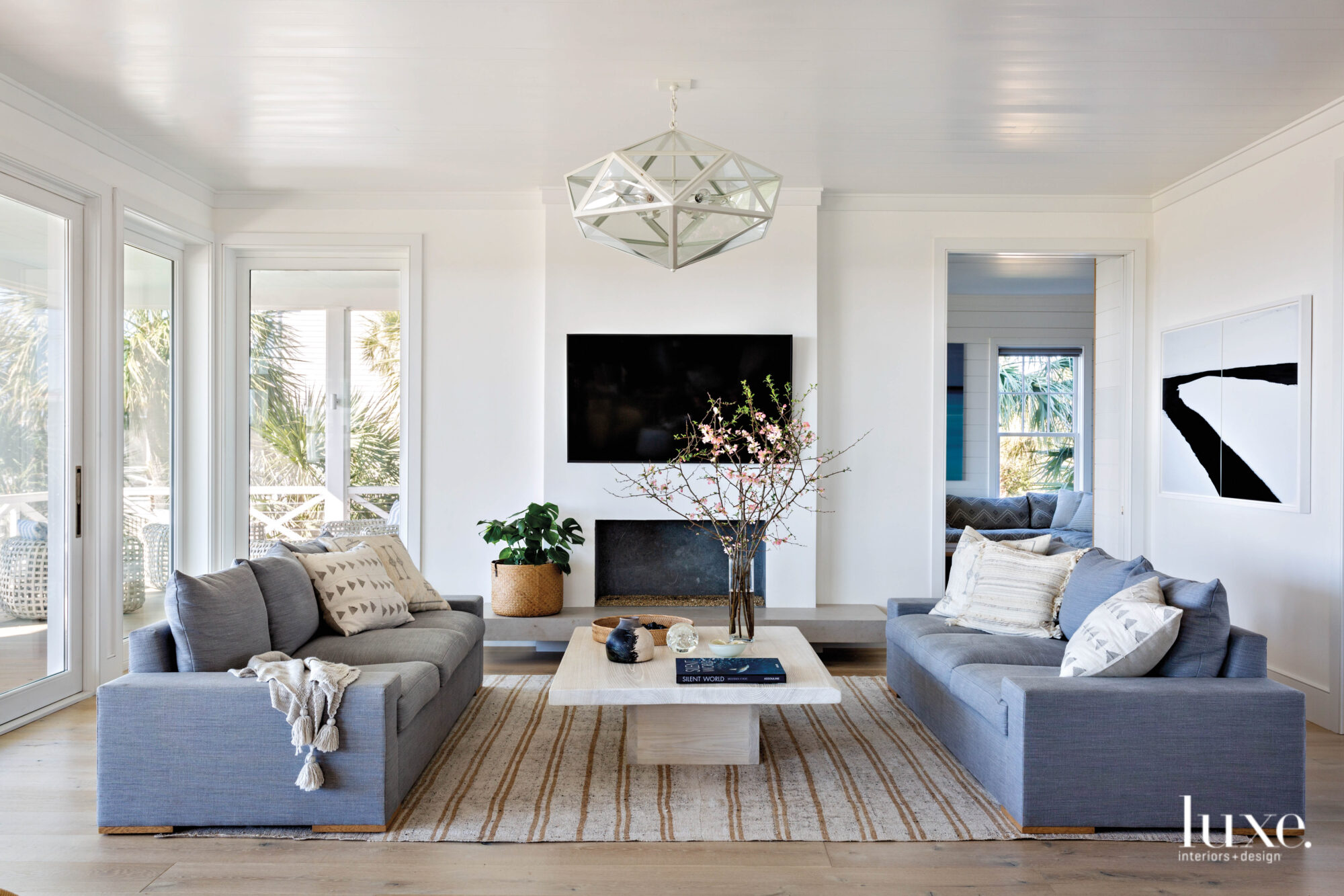 Living room with two sofas, low coffee table, striped rug, white walls