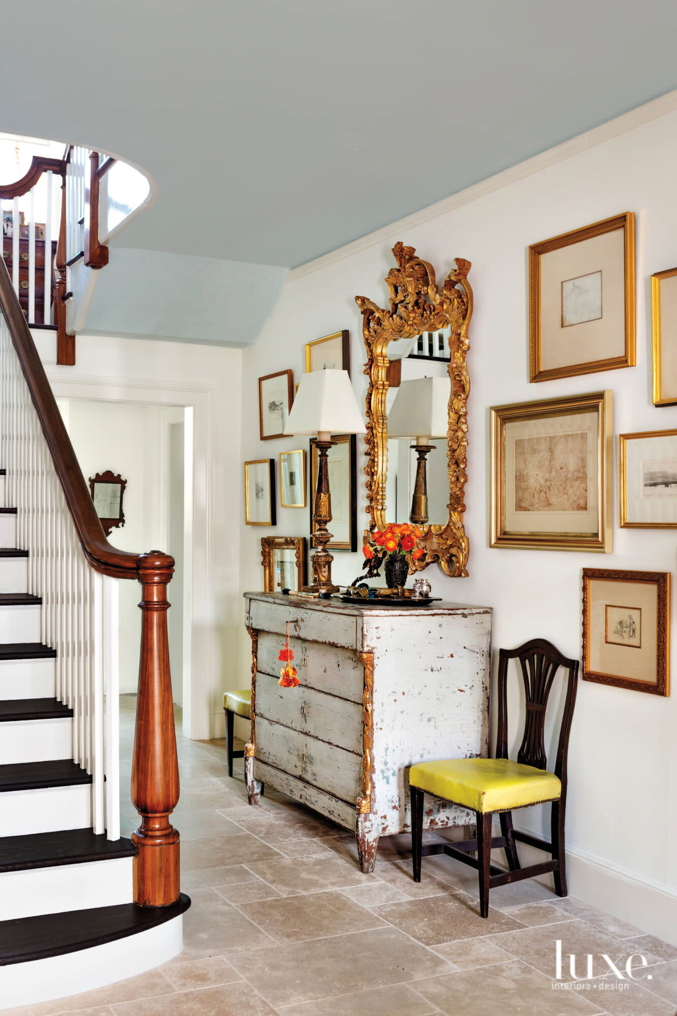 Hallway with stairwell, chest and framed pictures on the wall