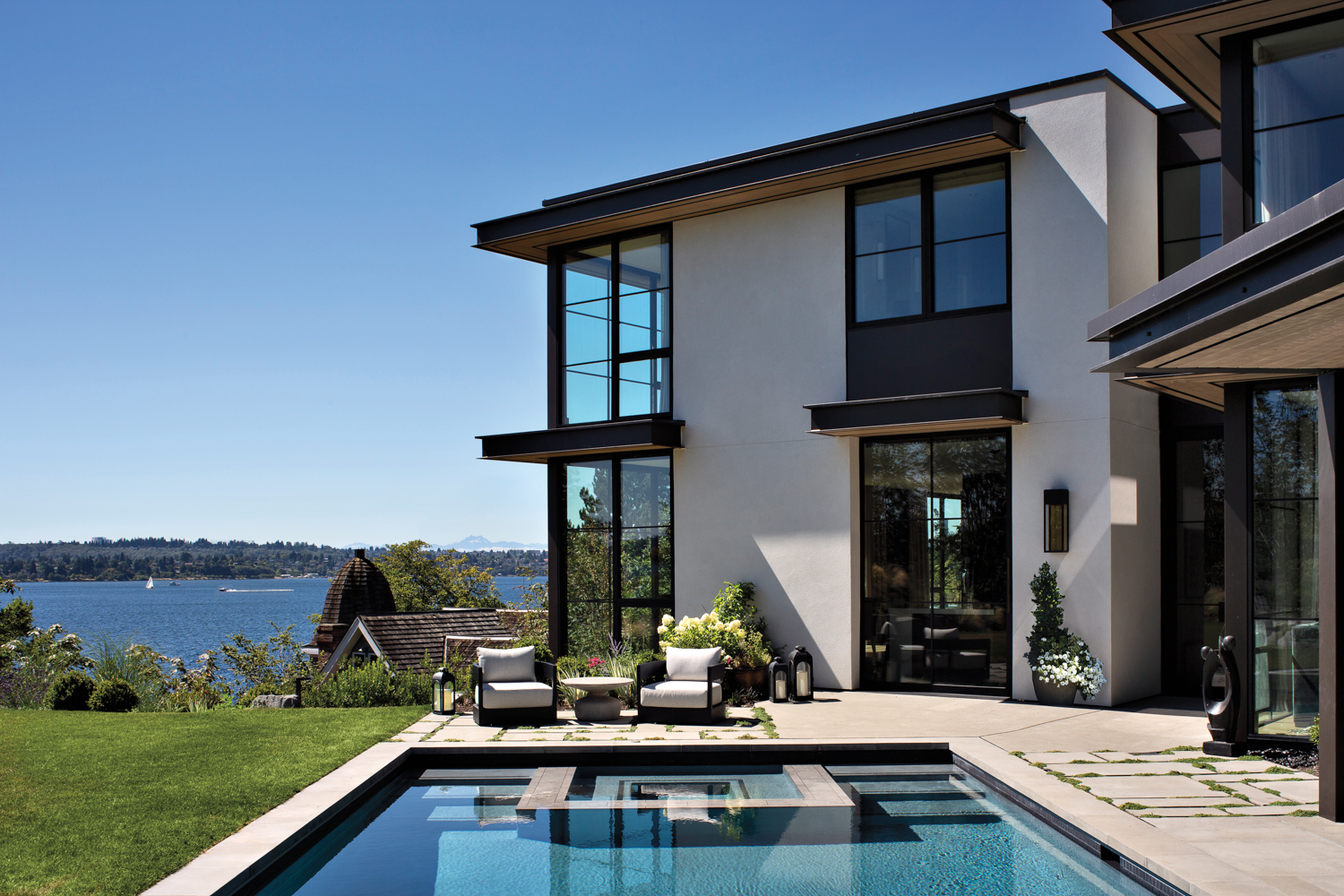 exterior of home by Jodi Cook overlooking pool and lake views