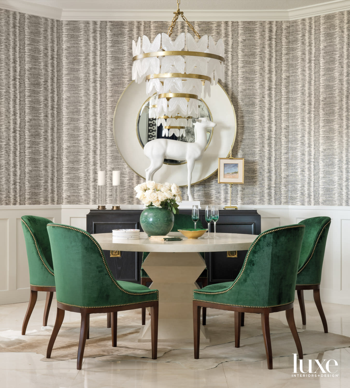 dining area with green chairs, round table and tiered chandelier