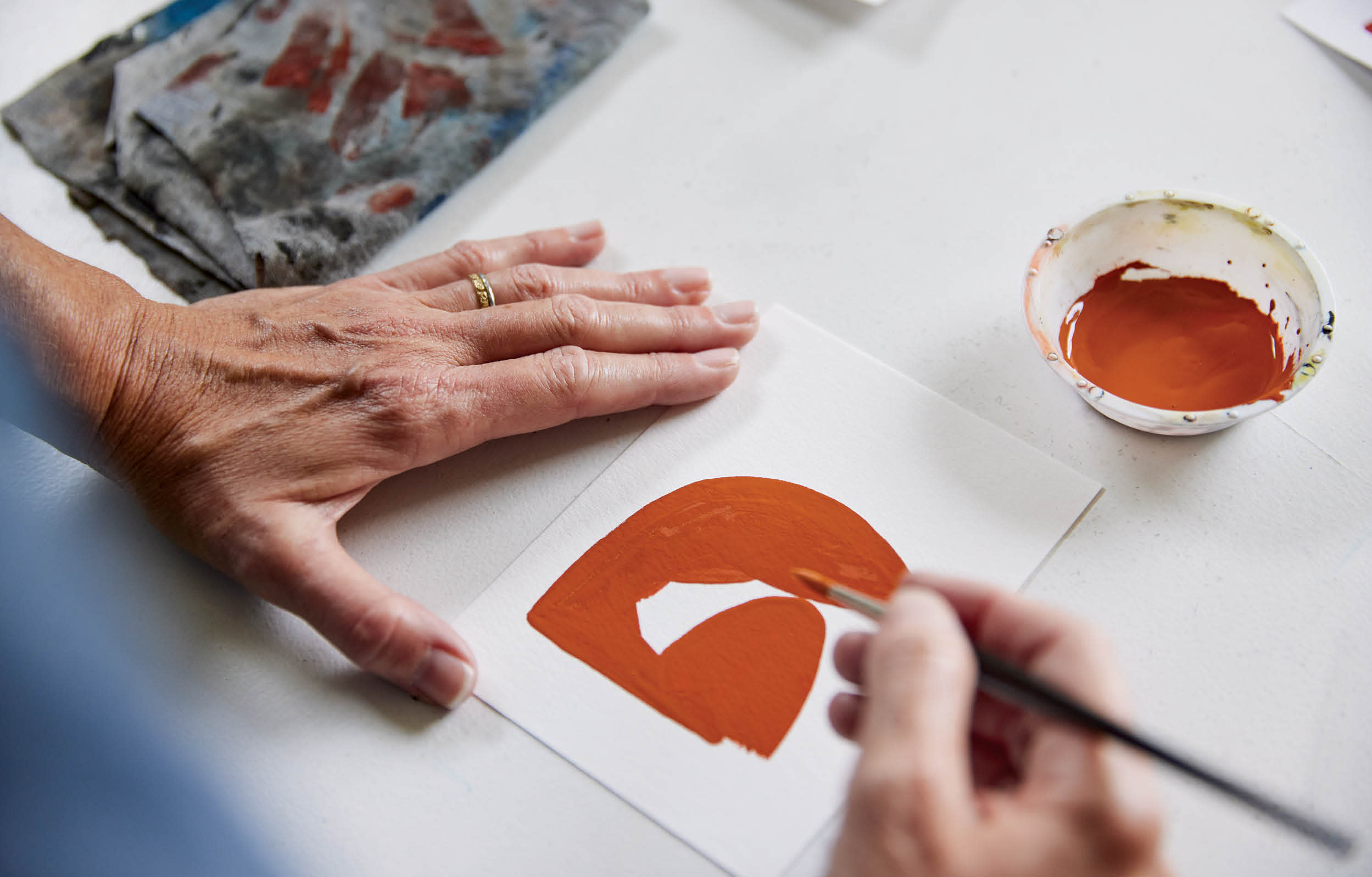 Amy Pleasant painting a figure using a red gouache paint