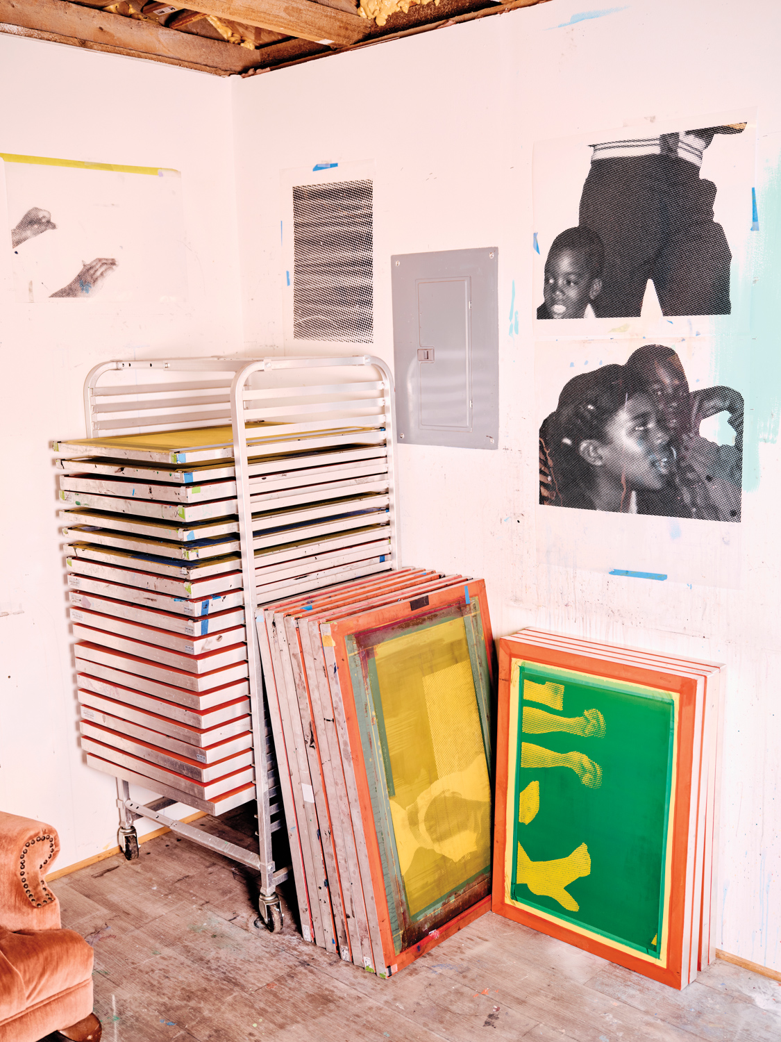 artist studio with white metal rolling rack of screens and transparencies for screen printing