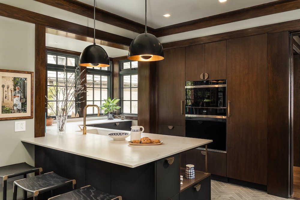 A contemporary kitchen featuring sleek dark cabinets contrasting elegantly with a luxurious marble countertop. The modern design incorporates stainless steel appliances and minimalist decor, creating a sophisticated culinary space.