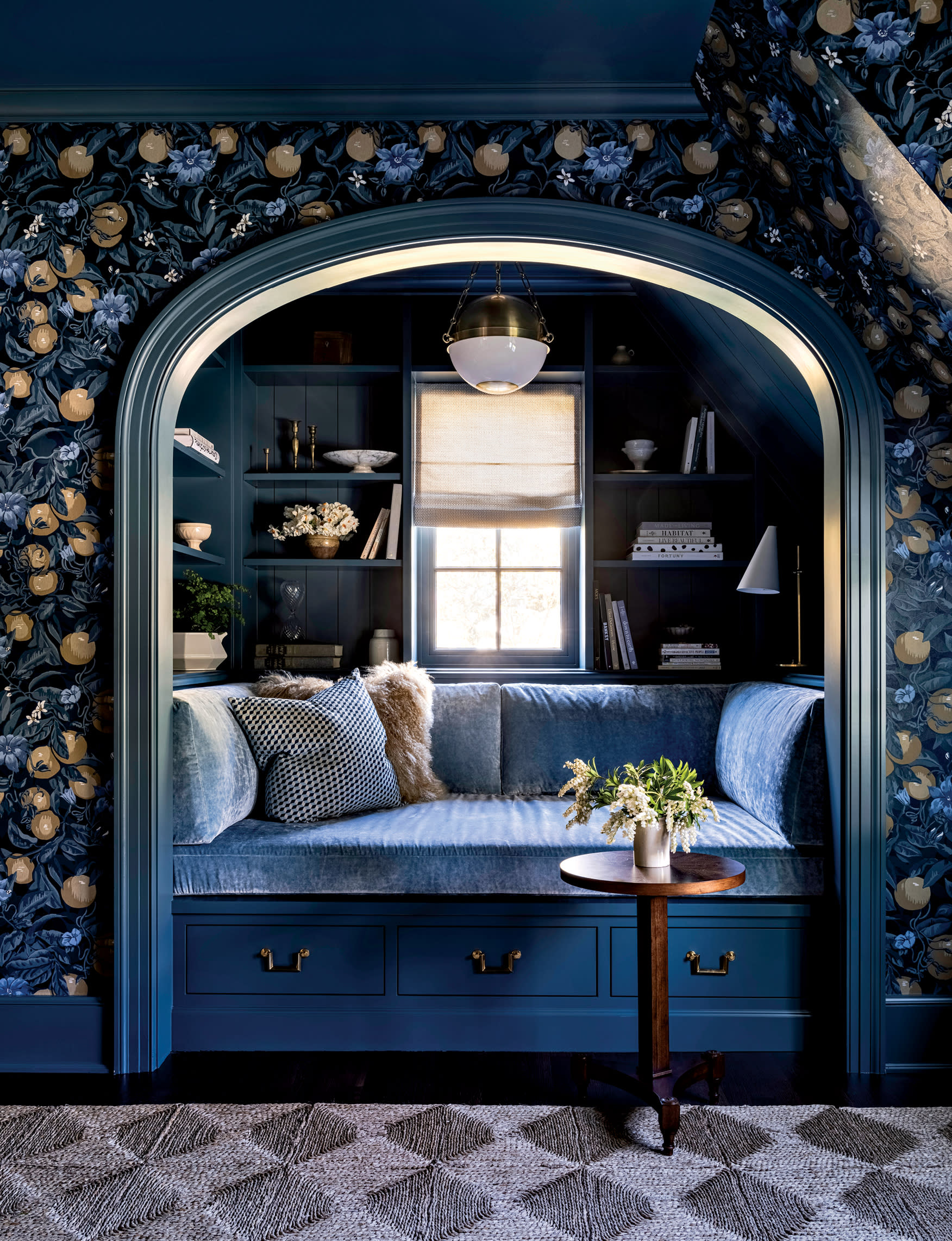 dark blue library nook with a yellow floral patterned wallpaper