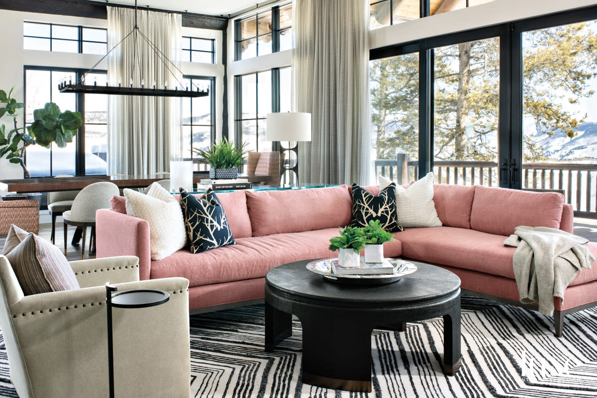 A blush-colored sectional provides comfortable seating in front of the fireplace.