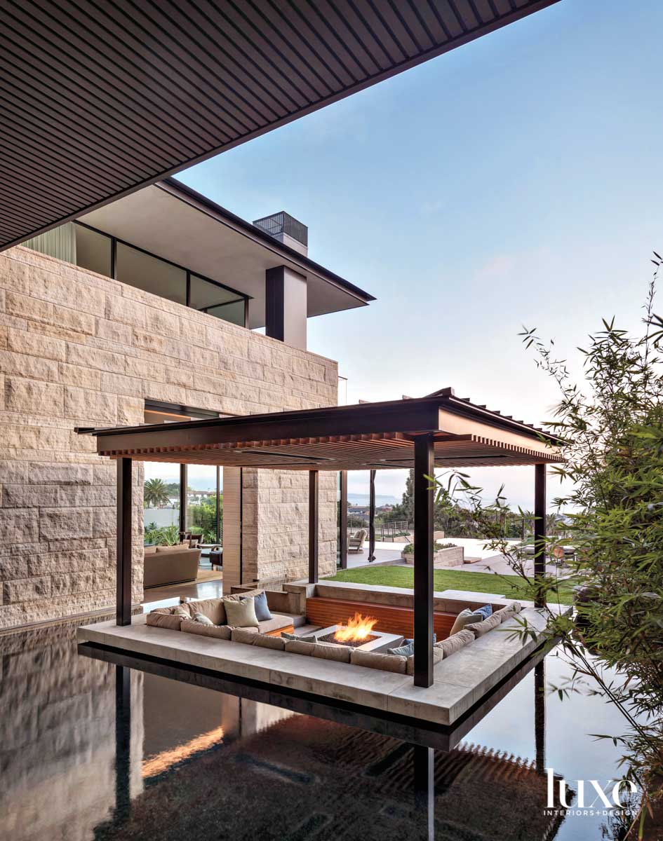 Covered outdoor seating area placed inside a reflecting pool in wellness room