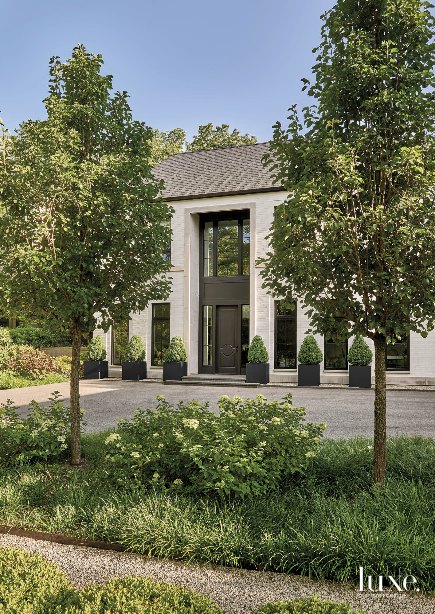 Outside shot of a stately white brick home with modern black trim.