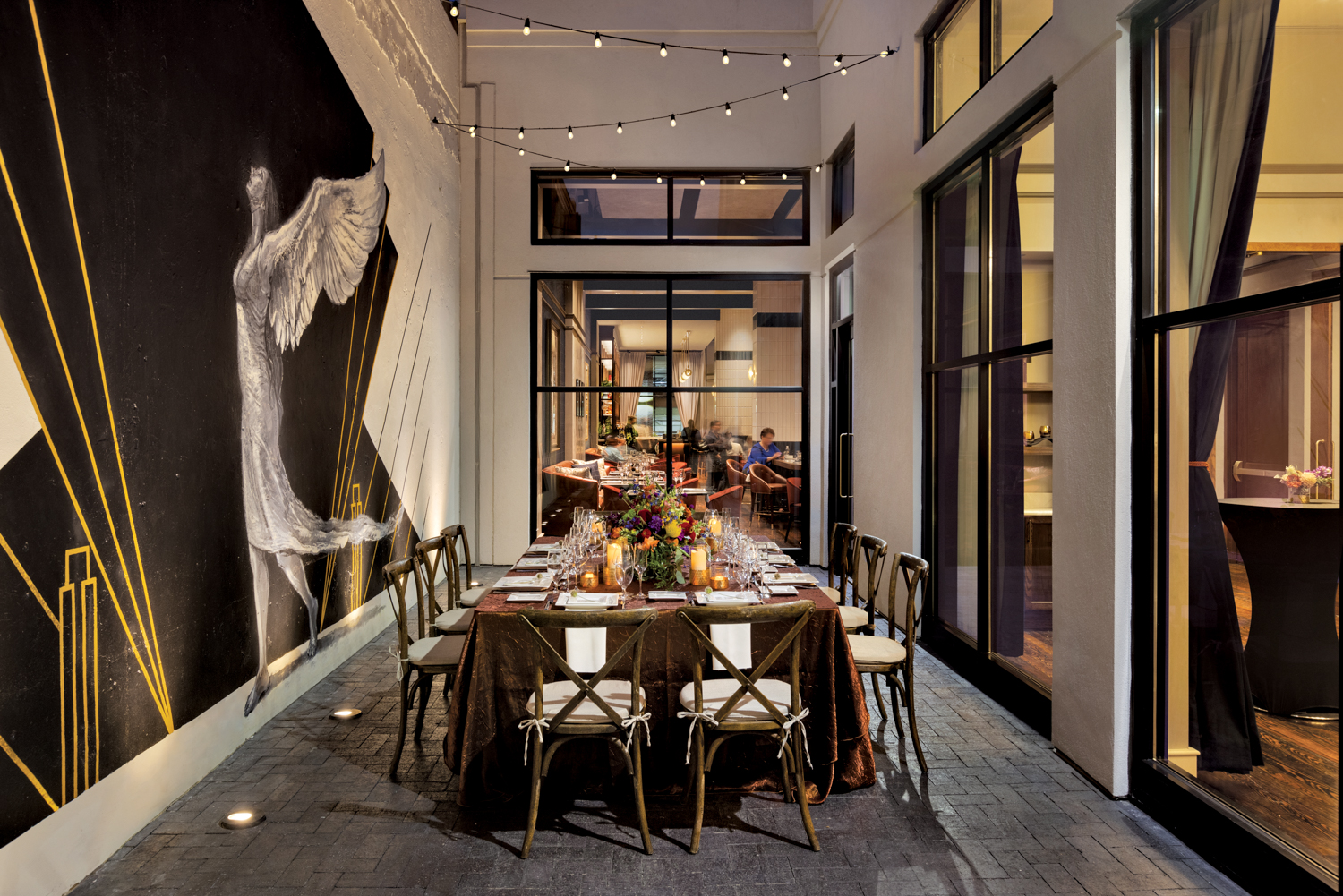 Patio dining area with glowing lights and oversize abstract art