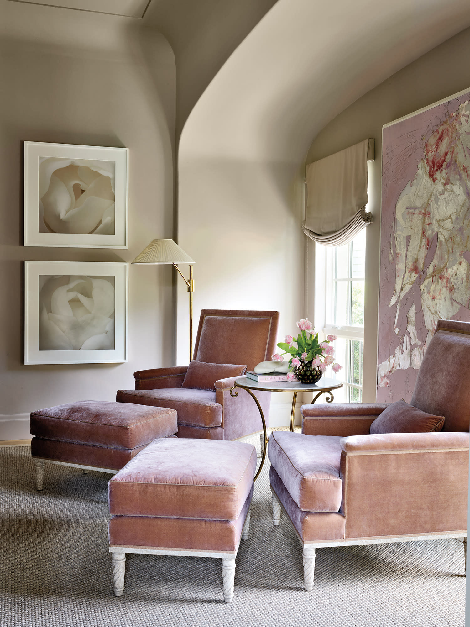 traditional seating area in a primary bedroom complete with pink velvet chairs