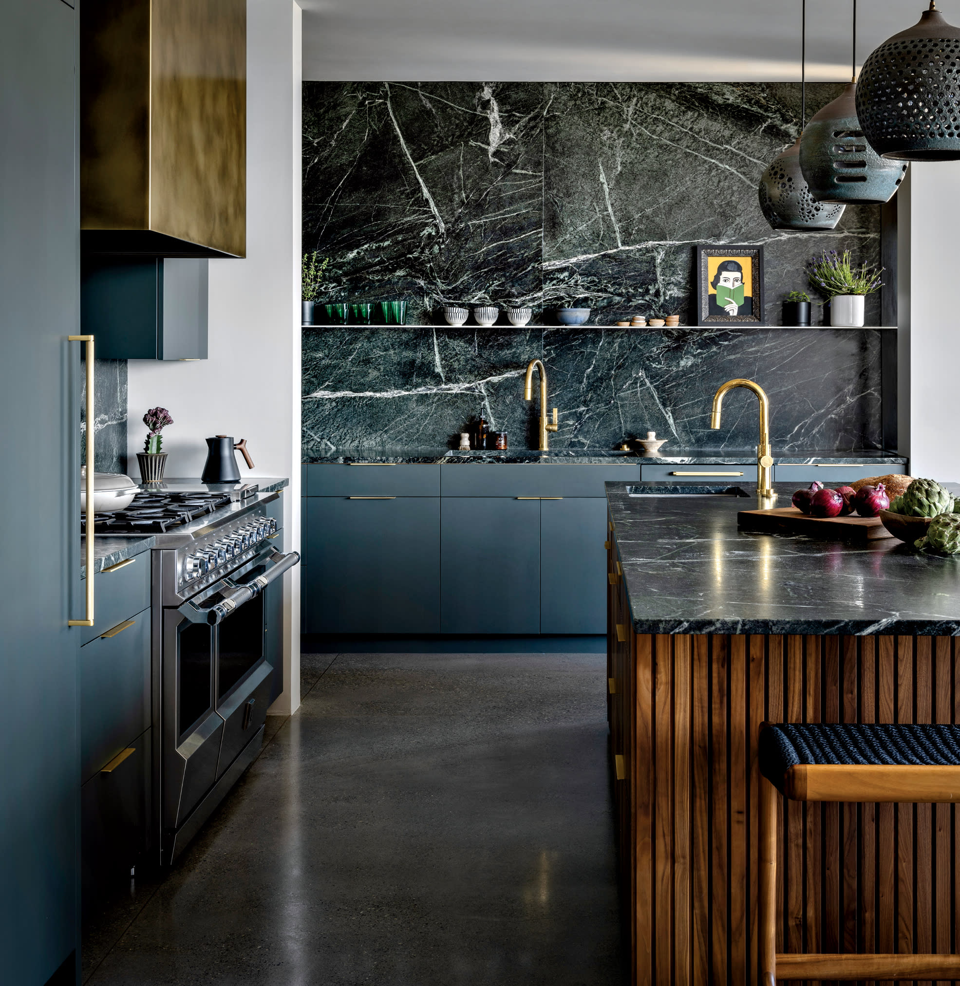 kitchen with blue cabinetry, soapstone backsplash and a blackened-brass range hood