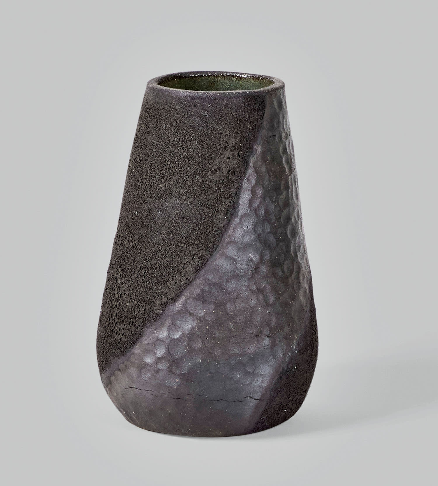 A black and gray angular vase on a light background.