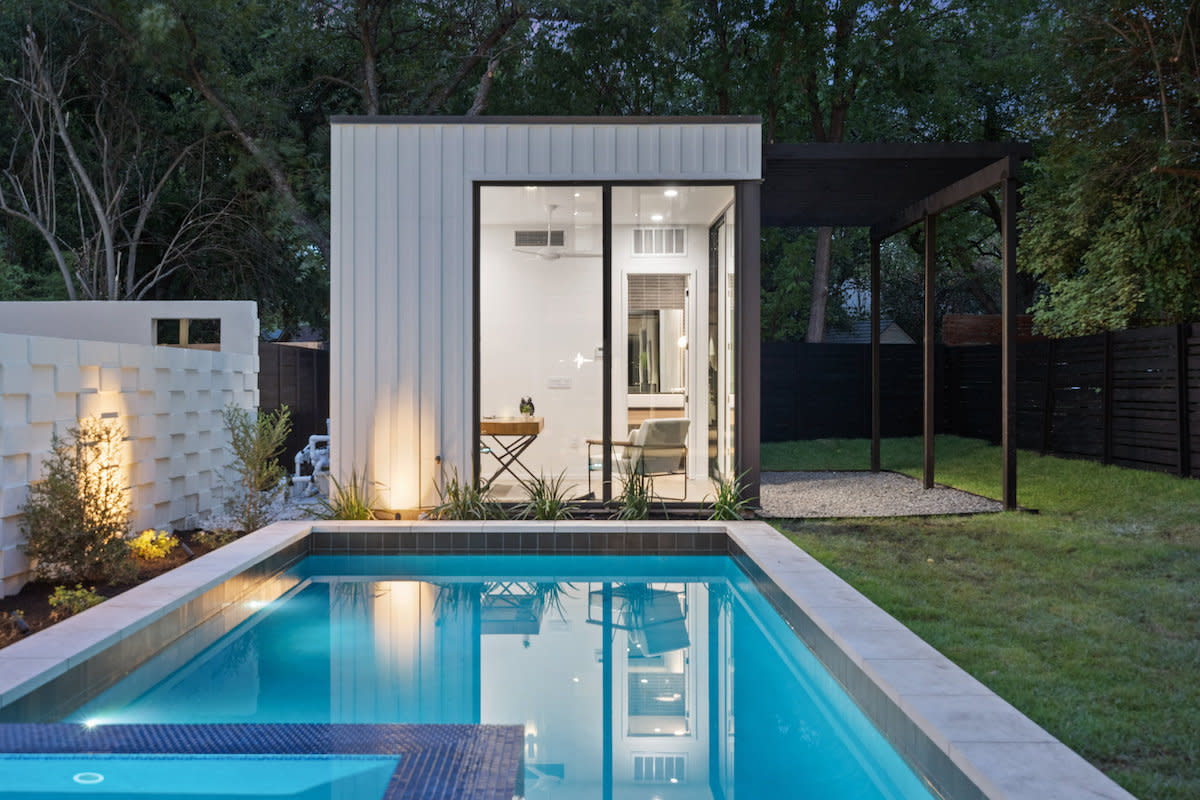 A contemporary pool house nestled in a compact backyard, offering a stylish and functional space for relaxation and entertainment.