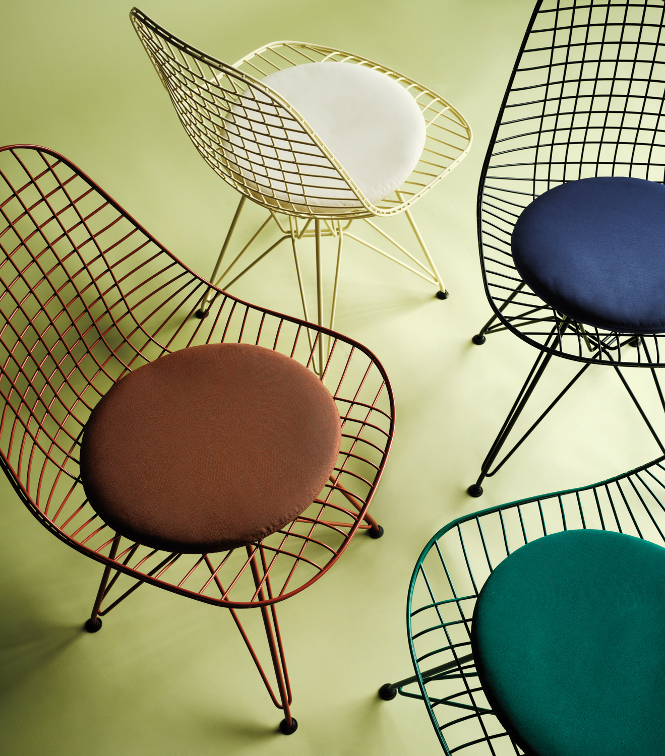 blue, green and brown wire chairs with cushion all staged on top of lime green flooring