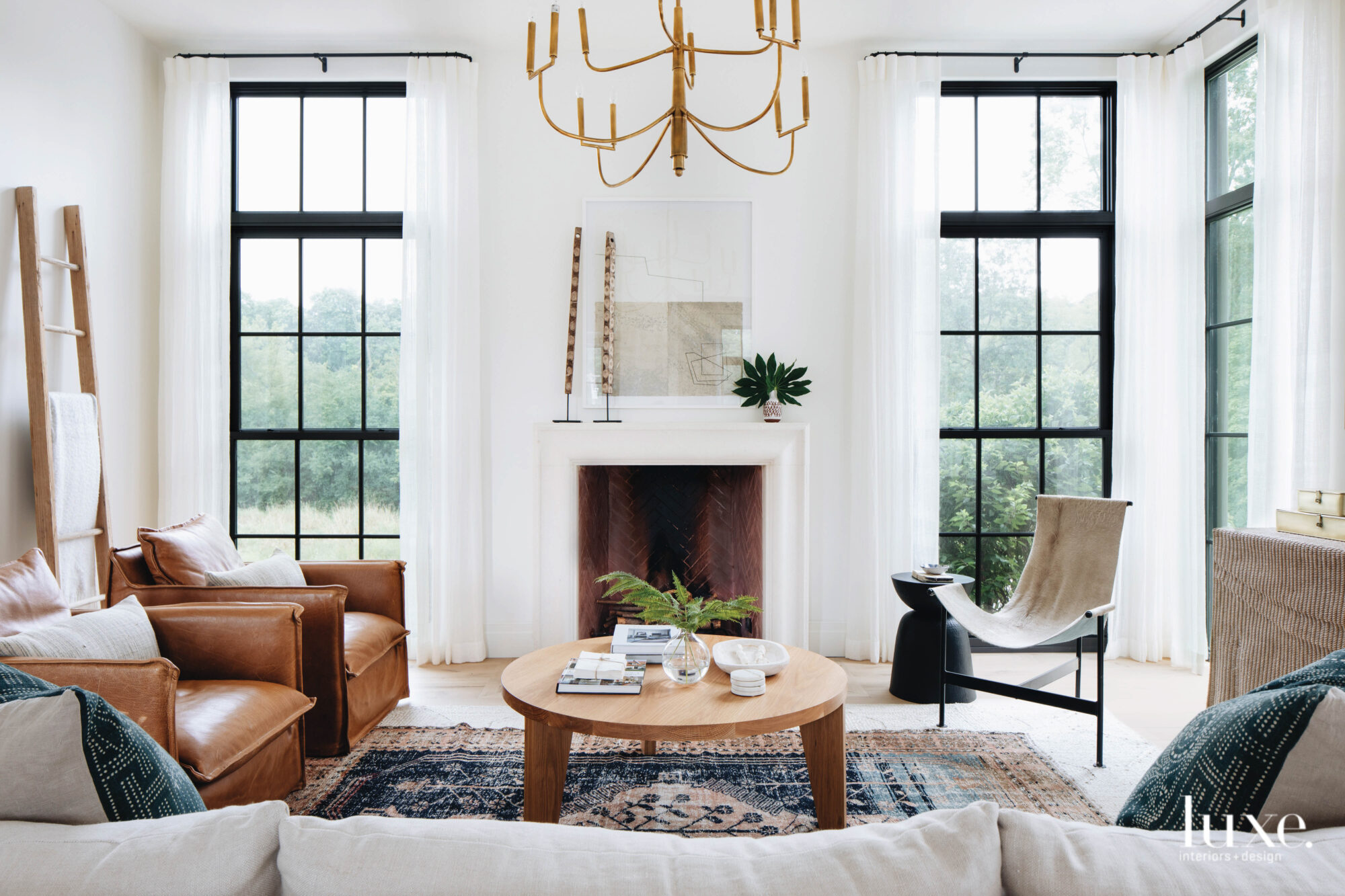 Huge windows glimpse at lush trees outside, providing the perfect atmosphere for this family room.