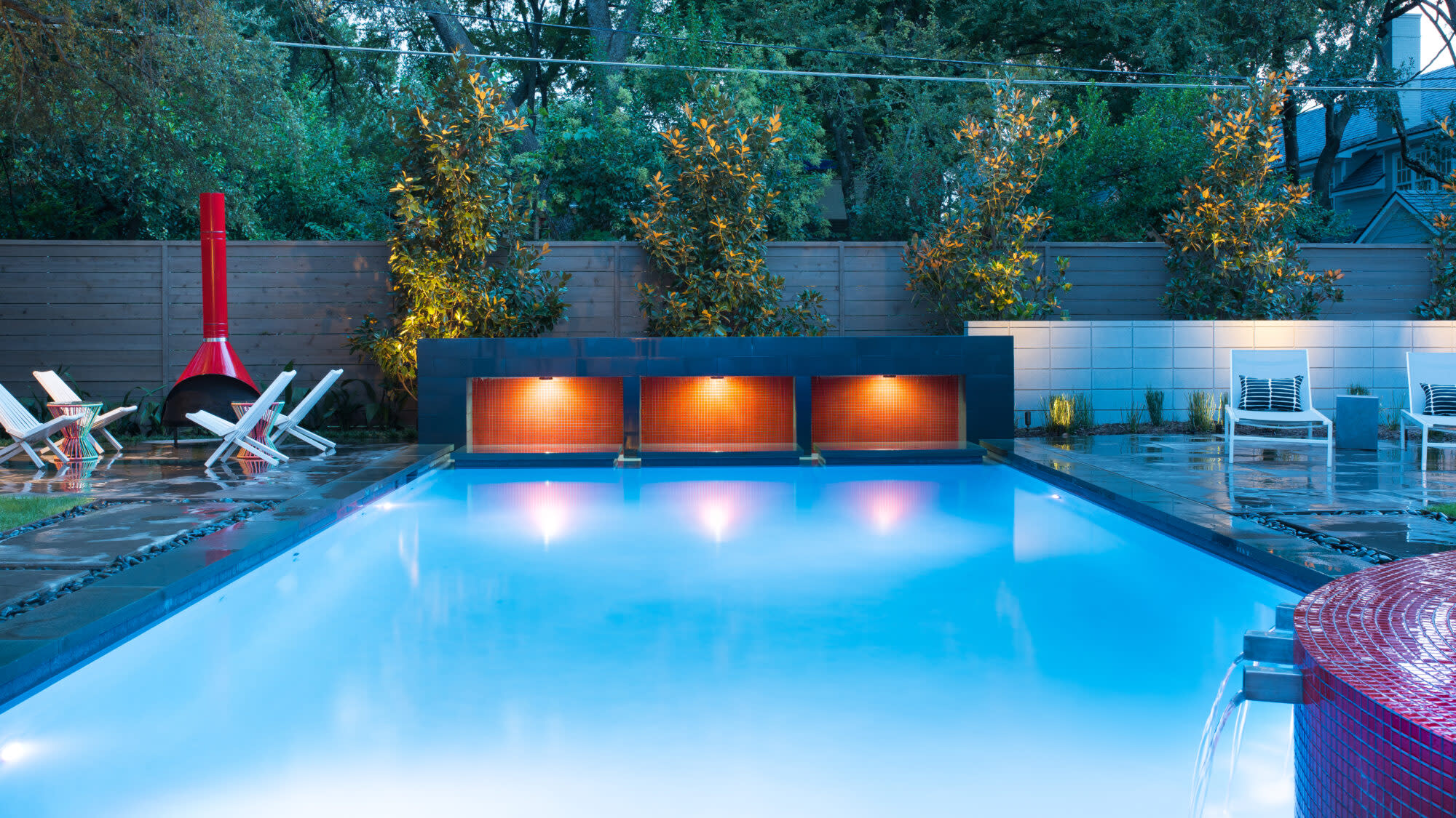 Evening-lit pool with glowing orange water feature