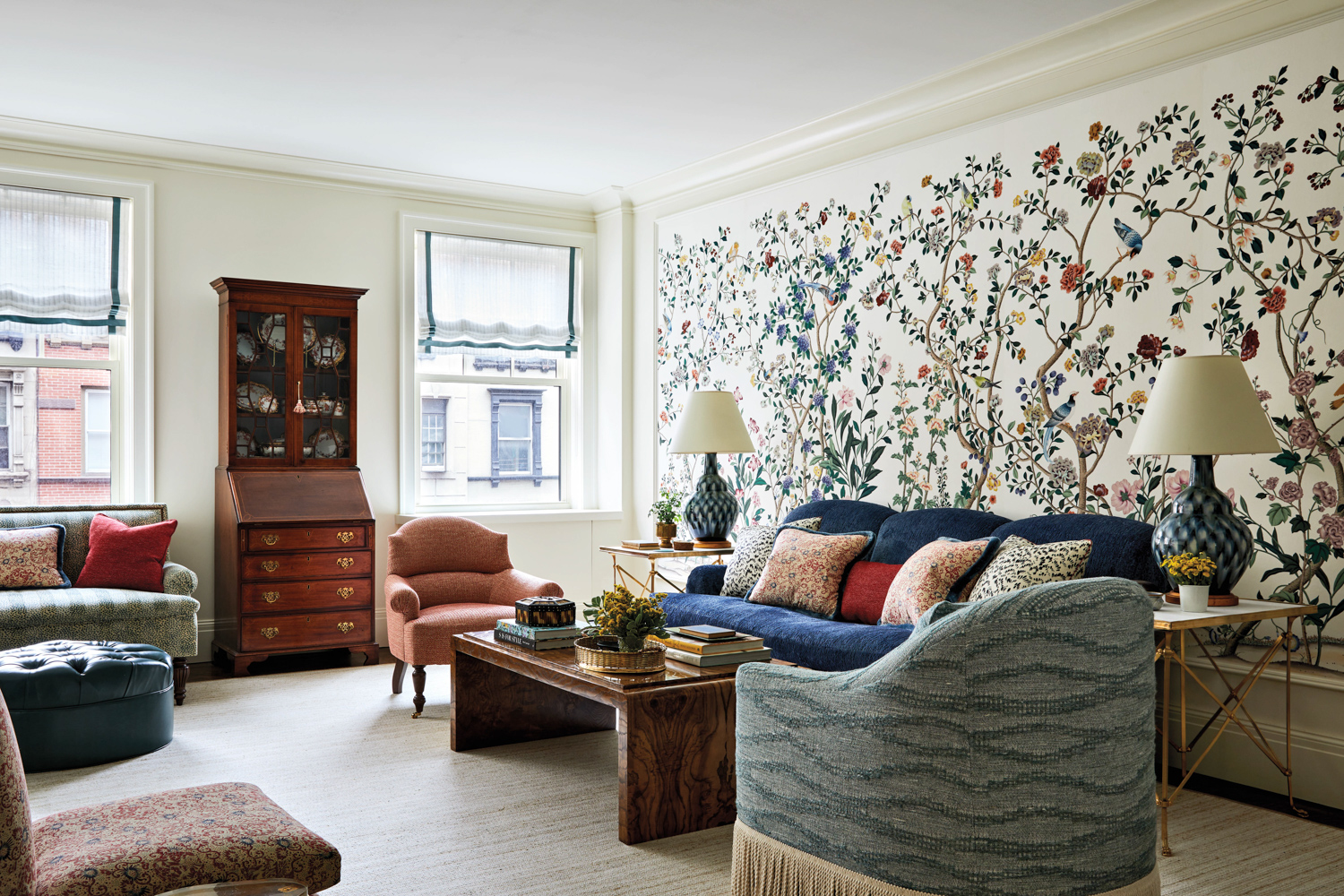 living room with De Gournay wallpaper, dark blue sofa, coffee table and pink chair by Emily Butler