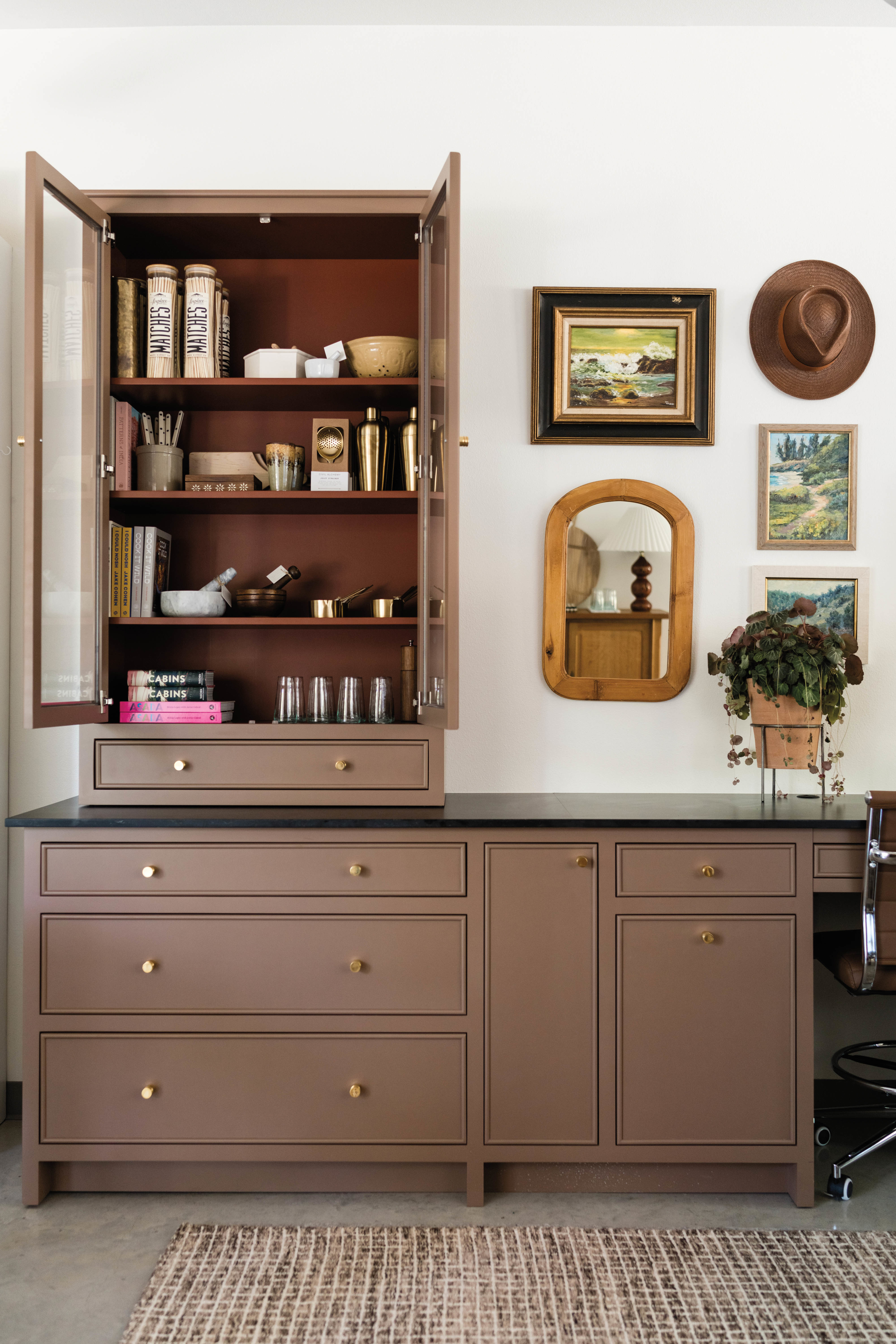 a brown cabinet topped with a matching shelf and various home goods