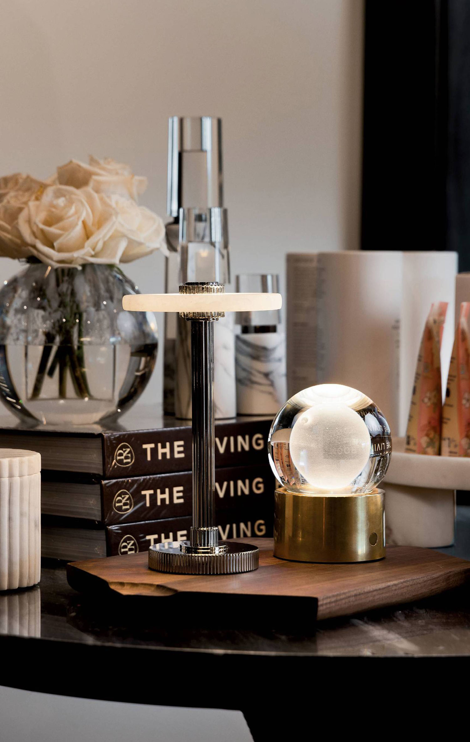 A wood table decorated with vases, books and other small items.