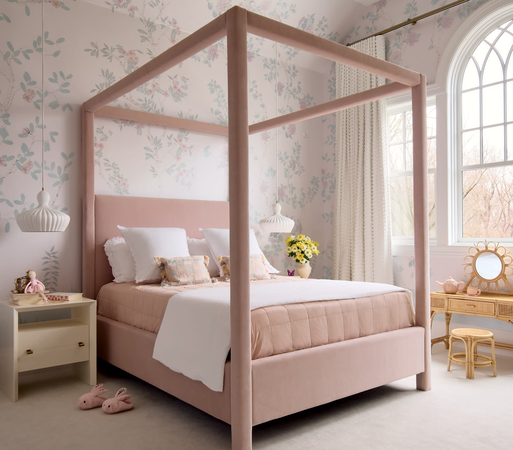 child's bedroom with a pink canopy bed and light pink floral wallpaper