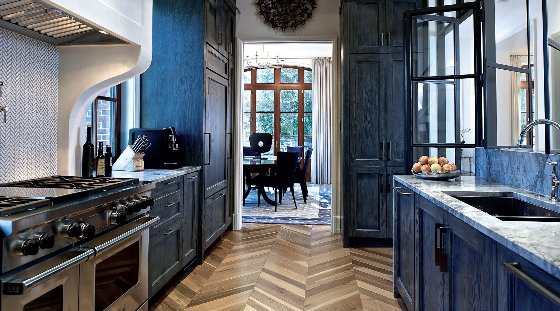 A bright kitchen featuring blue cabinets and warm wood floors, creating a cozy and inviting atmosphere.