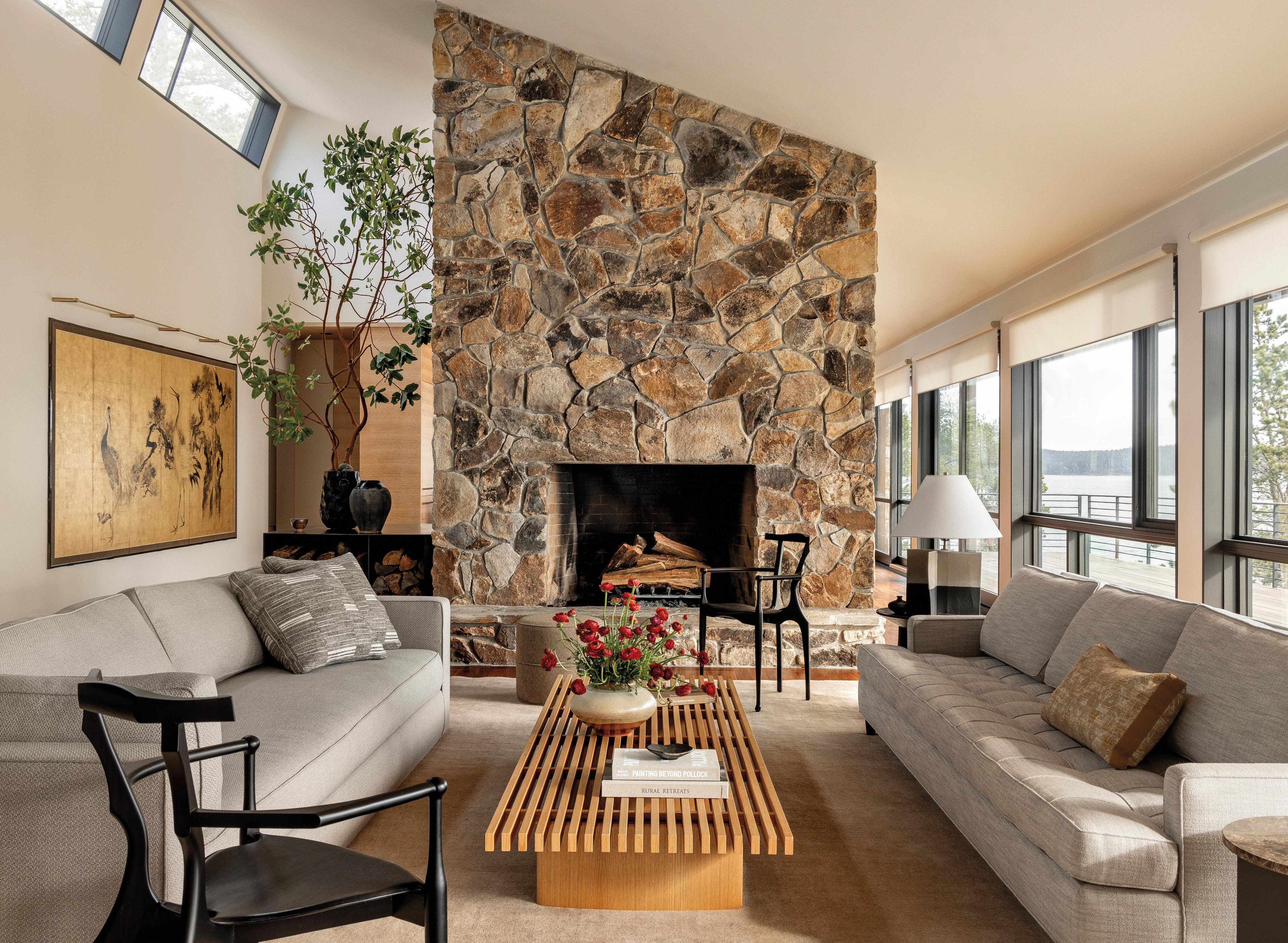 living room with stone fireplace and two sofas with wood bench coffee table 