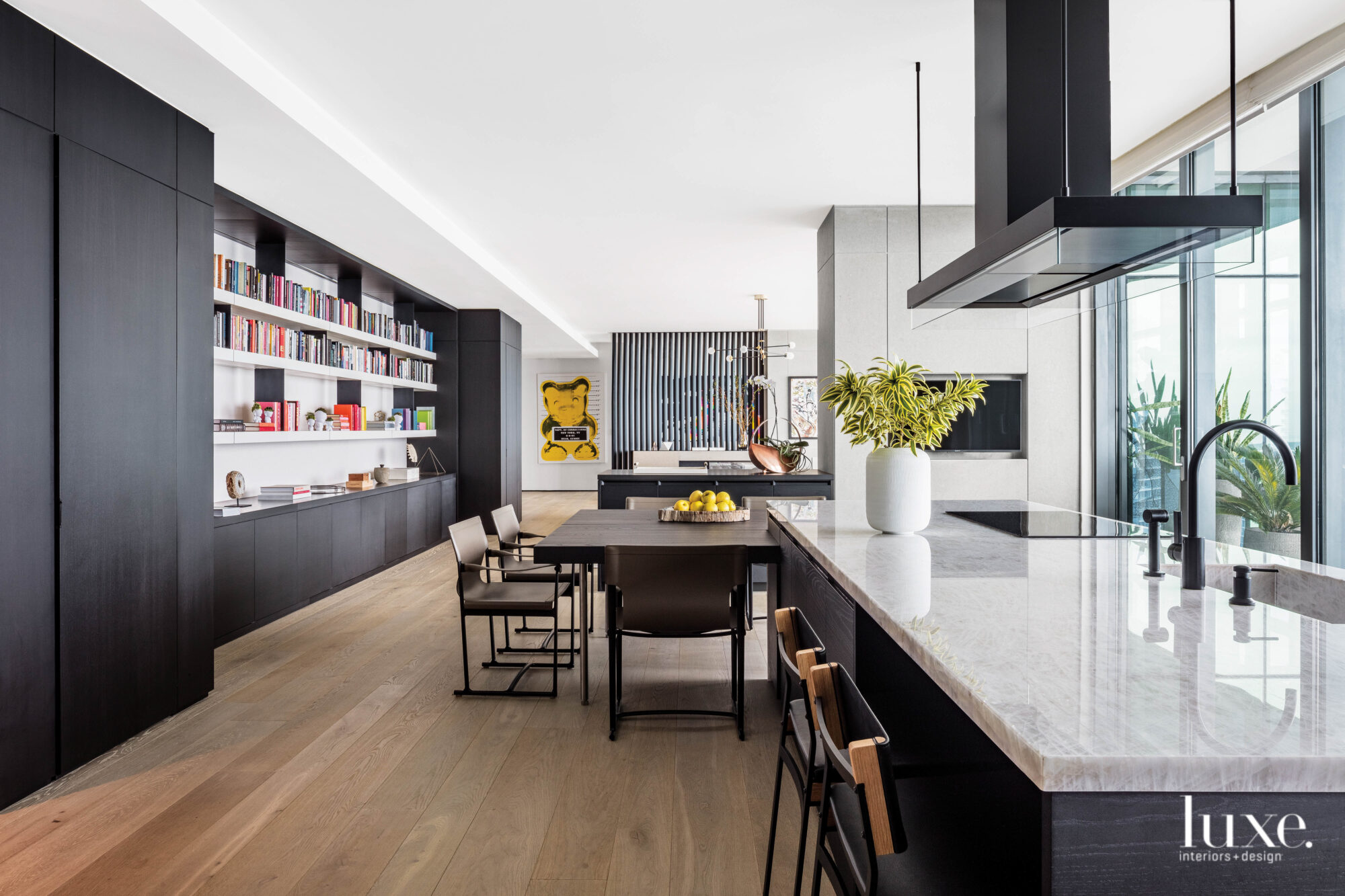 A modern, dark-toned kitchen with white quartz countertops.