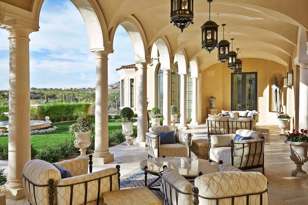 Patio with arched ceiling, stately columns and decorative lighting