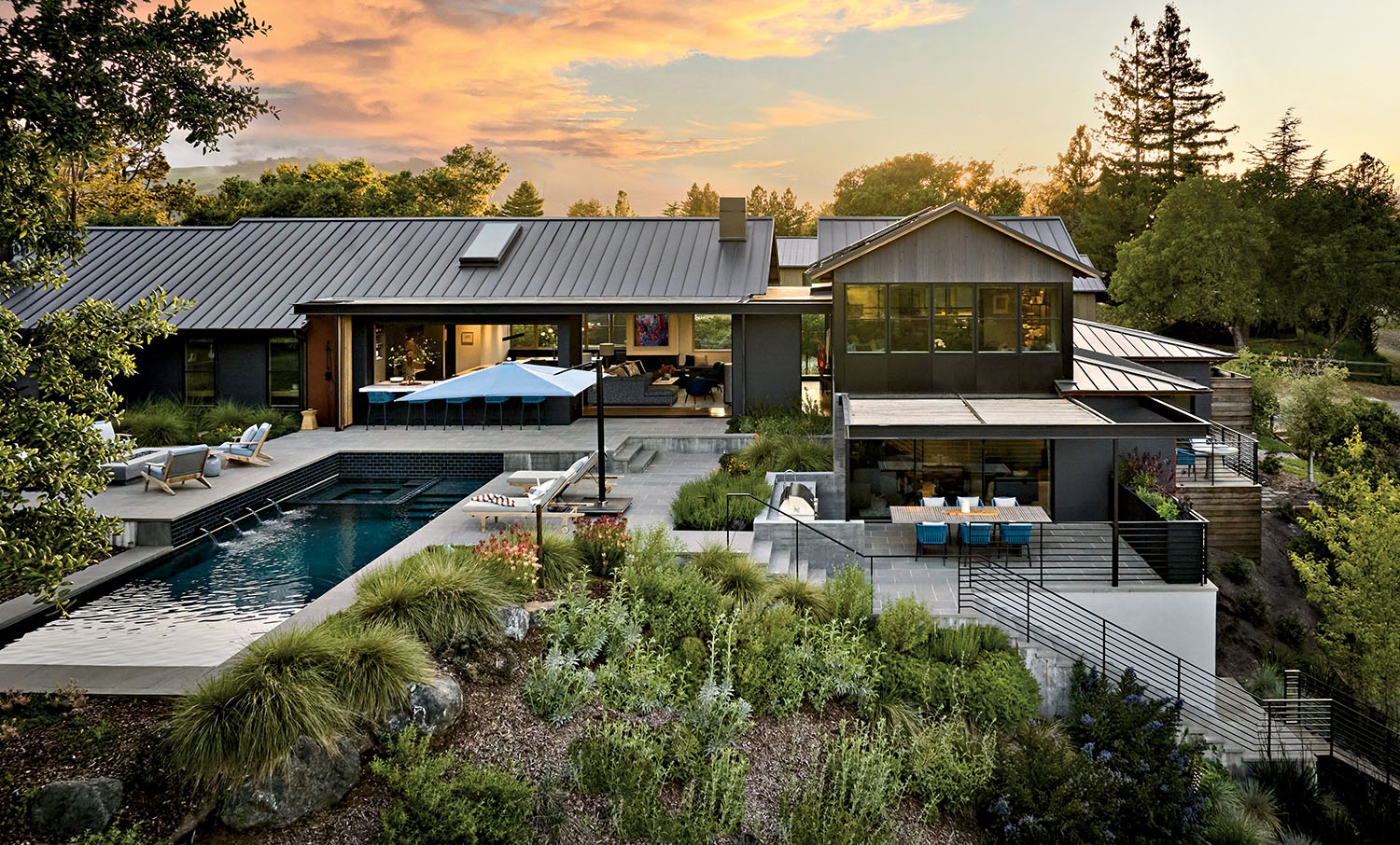 Modern house with sleek design, pool, and outdoor seating. Surrounded by lush greenery, set against a vibrant sunset skyline, conveying tranquility.