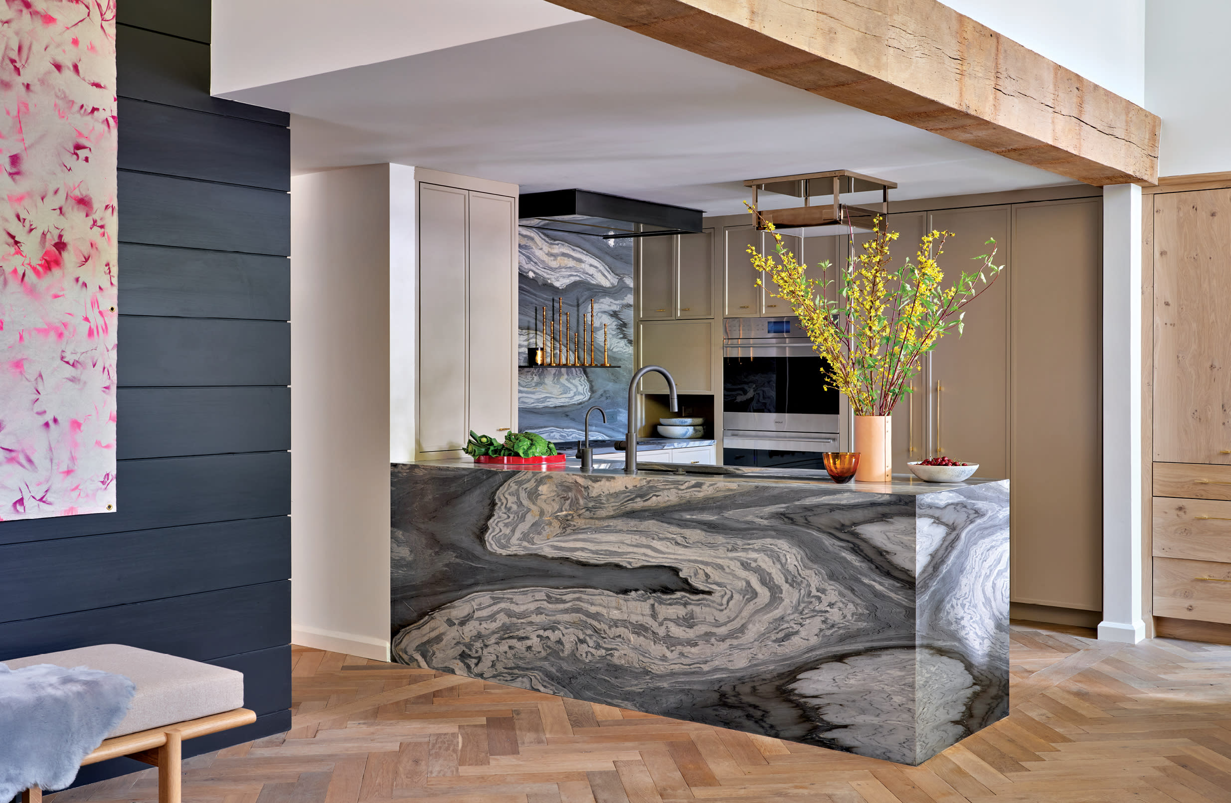 corner of a home's great room with a monolithic slab of leathered Calacatta Cielo in the kitchen