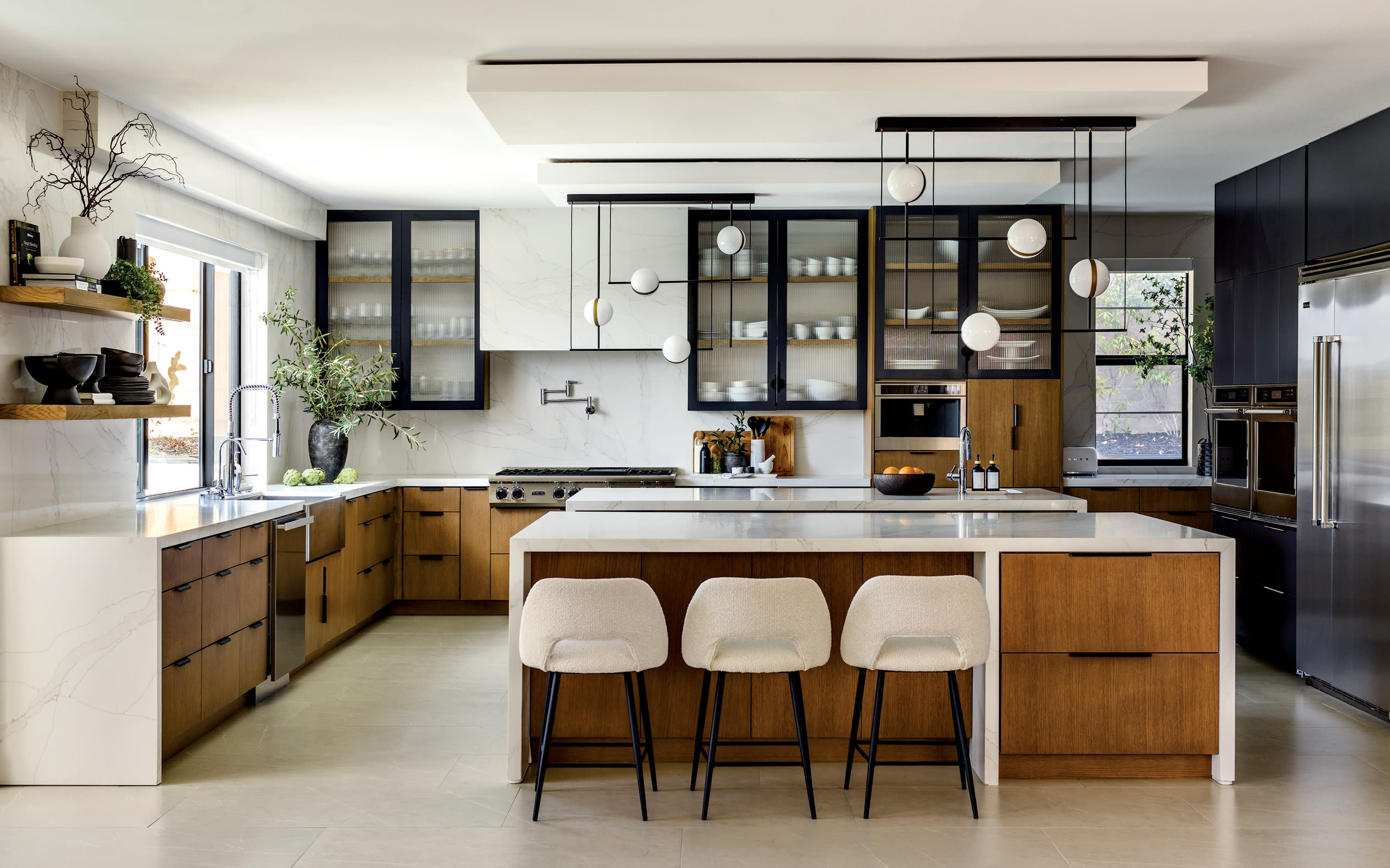 open concept kitchen with light oak wood cabinetry and white quartz countertops