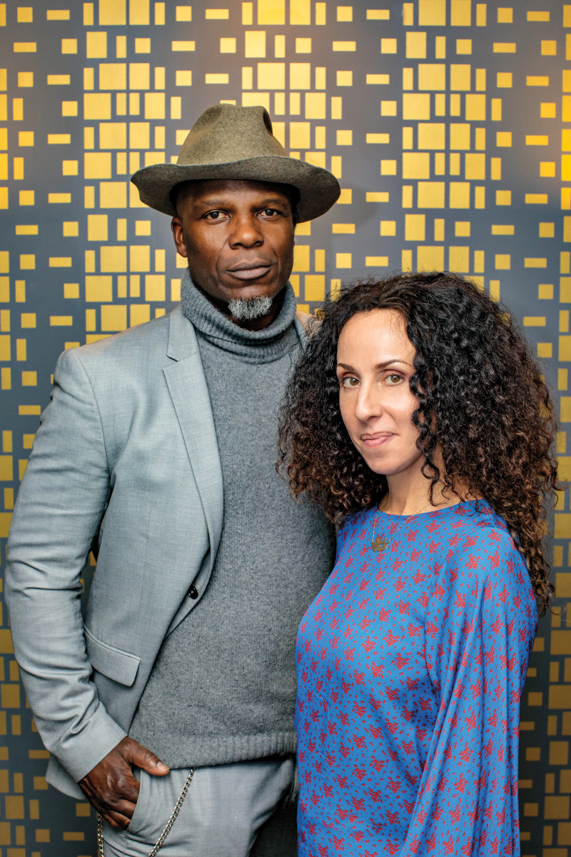 woman and man posing in front of gold and blue background