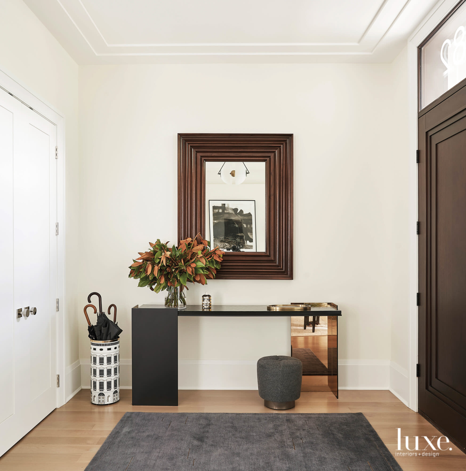 The foyer's gray rug, black console and dark decor set a sophisticated tone.
