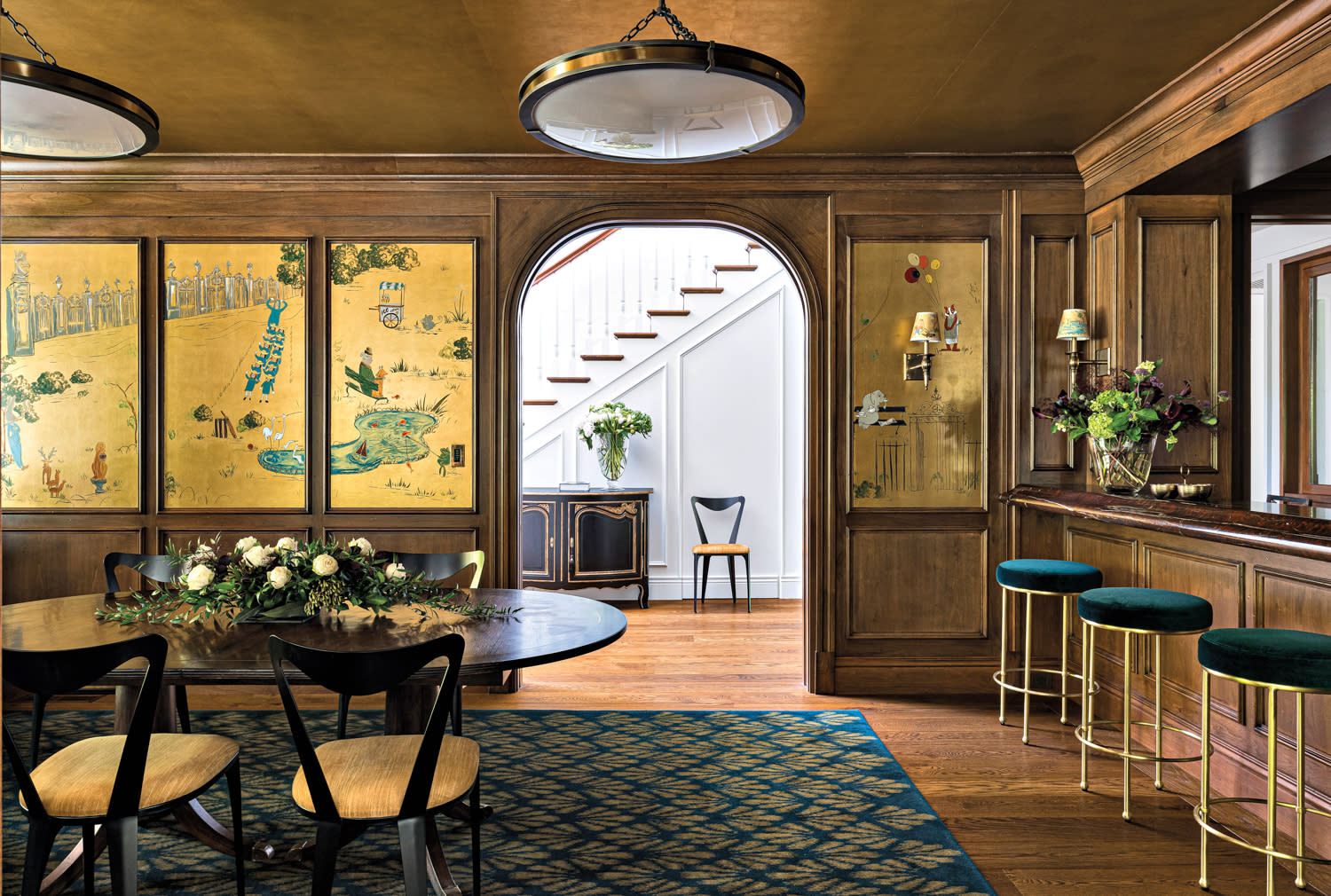 Elegant dining room showcasing gold and blue walls alongside a sophisticated gold and blue bar for a refined look.